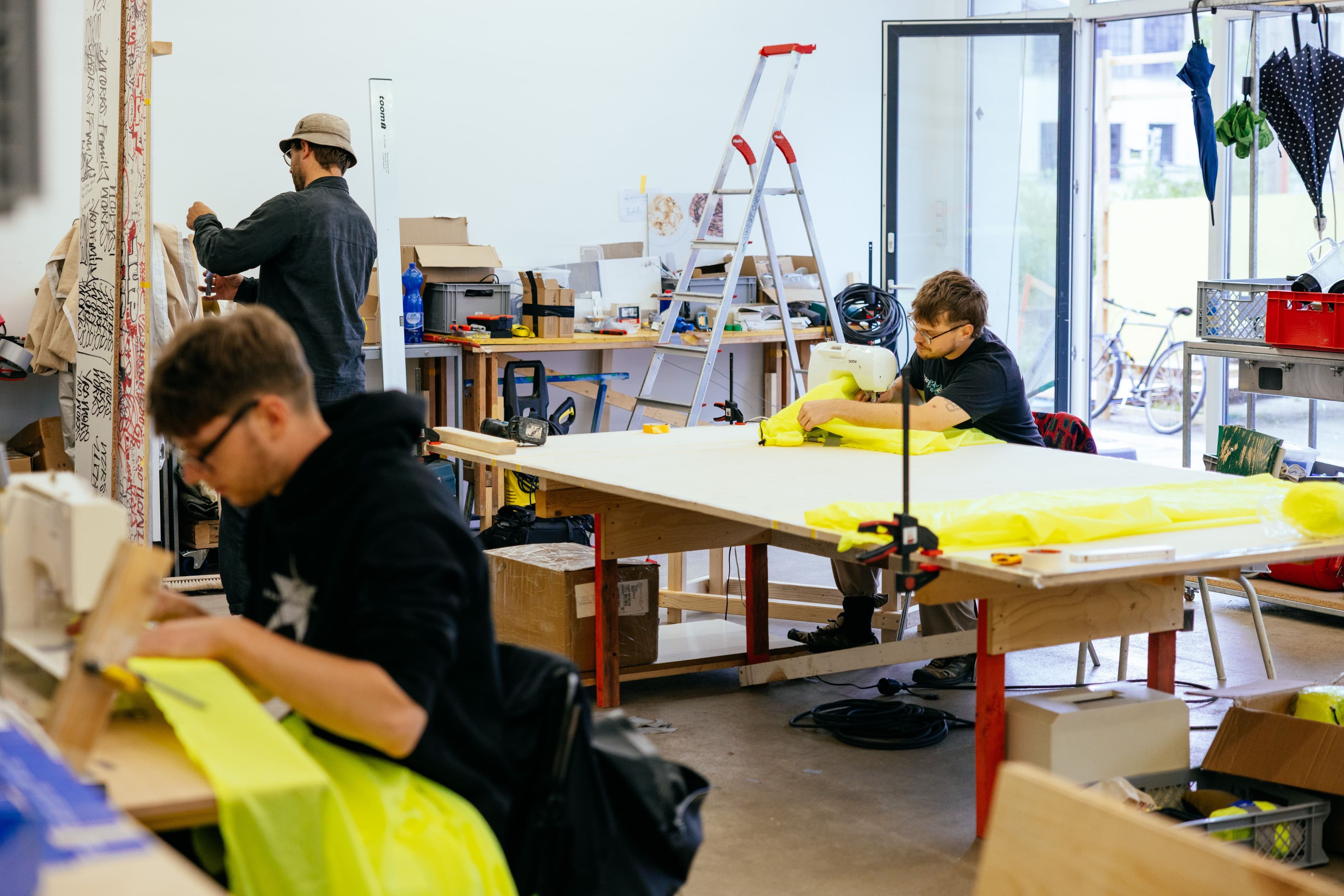Drei Männer arbeiten in einer Werkstatt