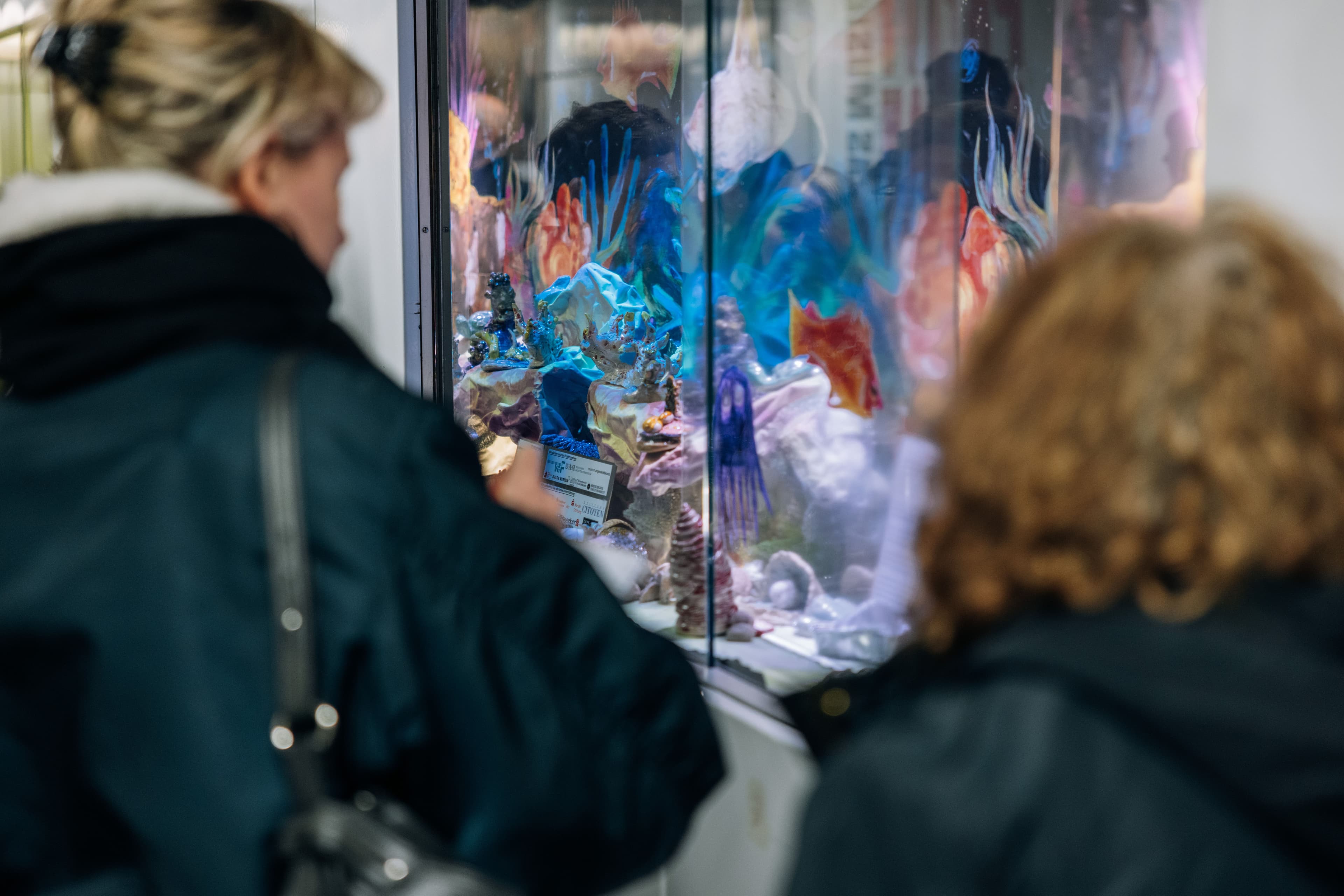 Zwei Frauen schauen sich die Schaukästen mit Kunstaktionen des Projekts "Domäne S" in der Frankfurter Hauptwache an.