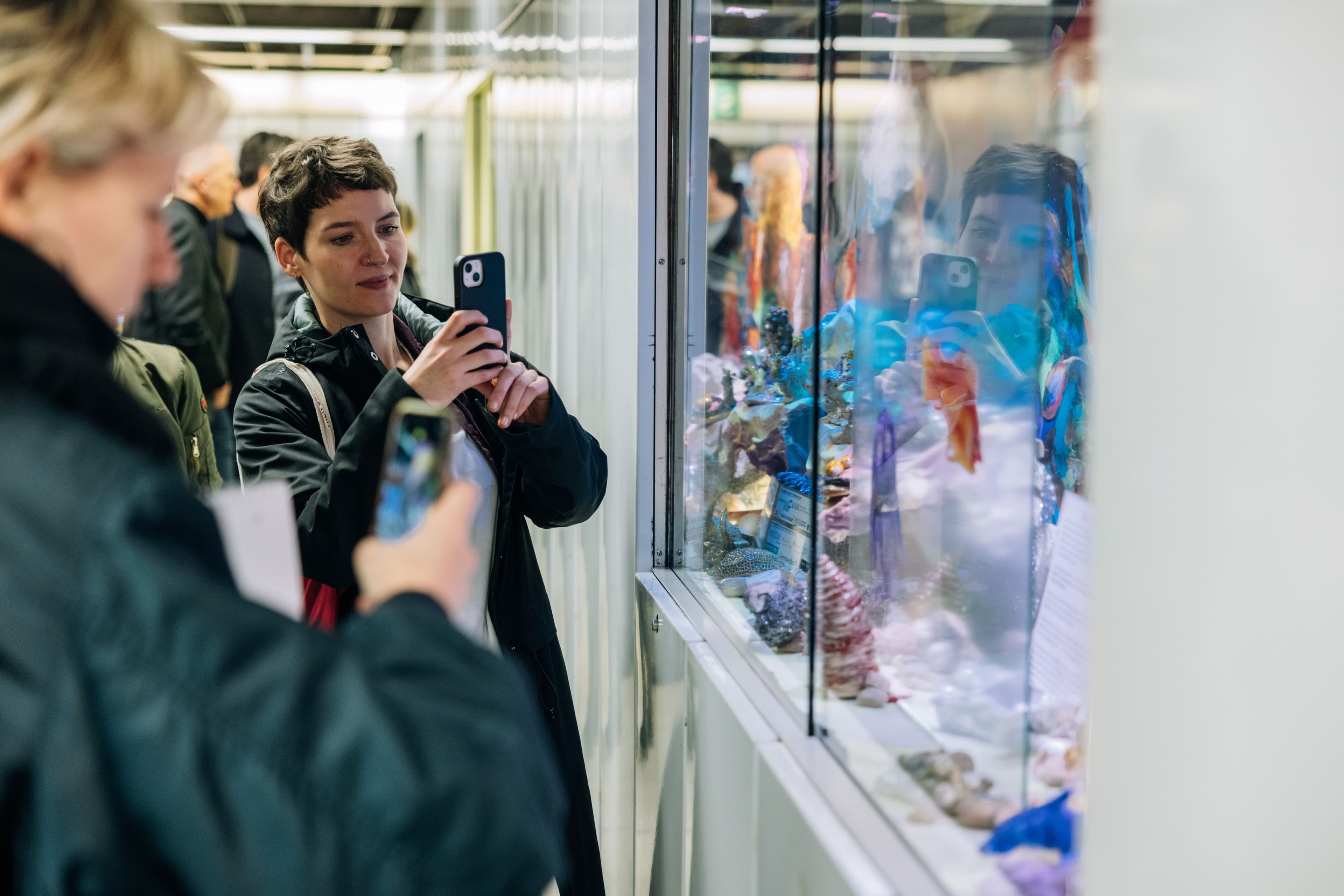 Besucher schauen sich die Schaukästen mit Kunstaktionen des Projekts "Domäne S" in der Frankfurter Hauptwache an.