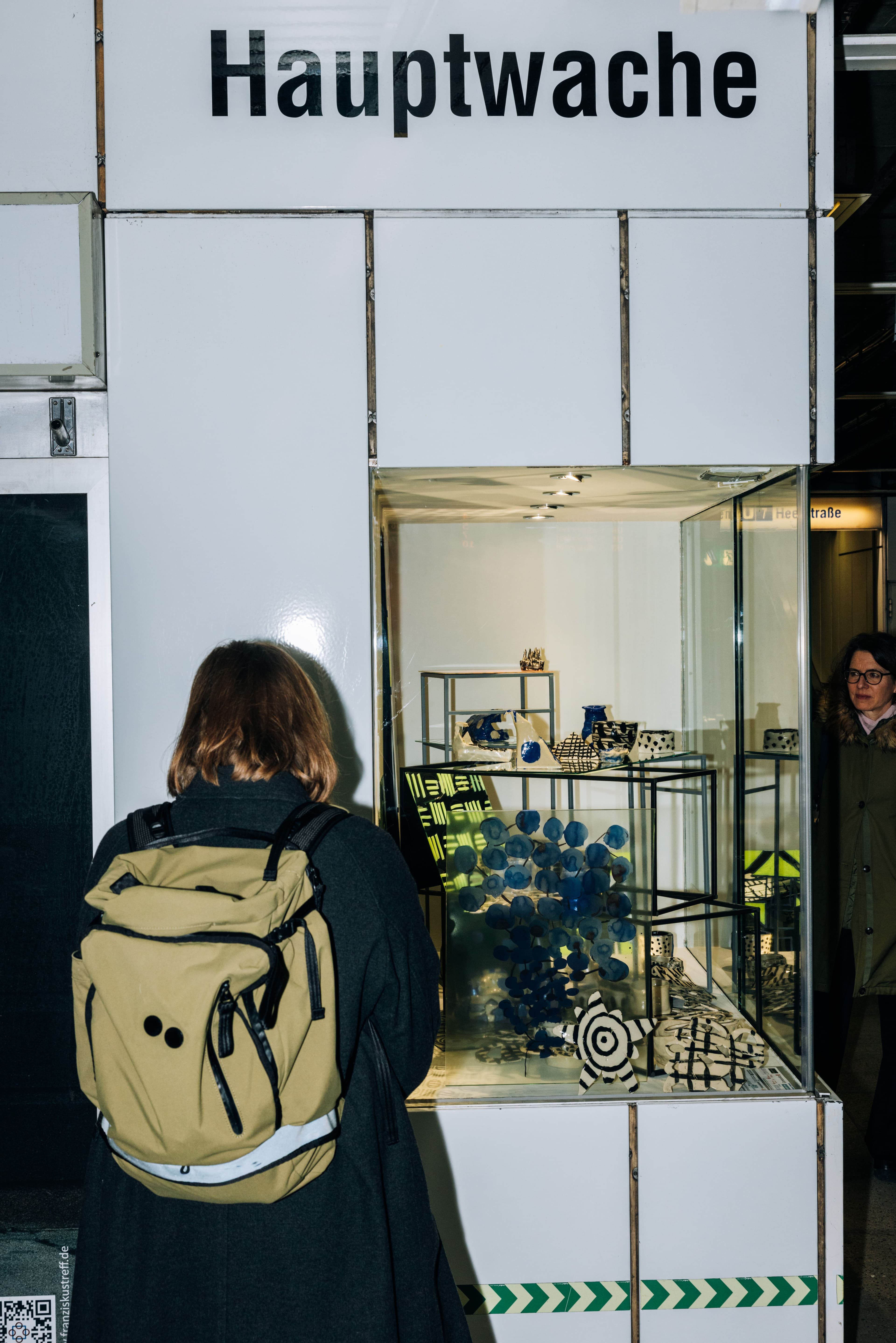 Ein Kind steht vor einer Glasvitrine mit einer Miniaturwelt.