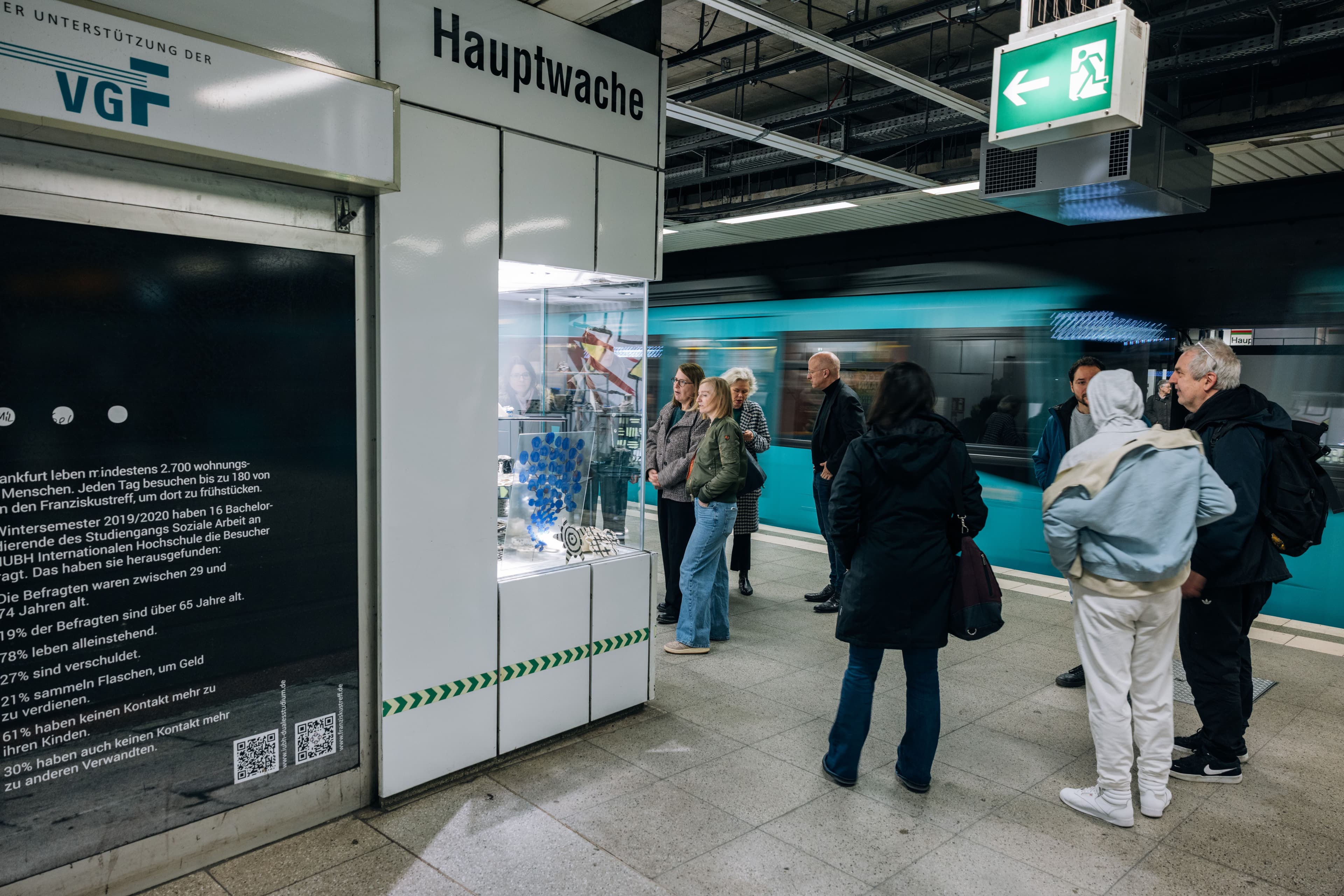 Besucher schauen sich die Schaukästen mit Kunstaktionen des Projekts "Domäne S" in der Frankfurter Hauptwache an.