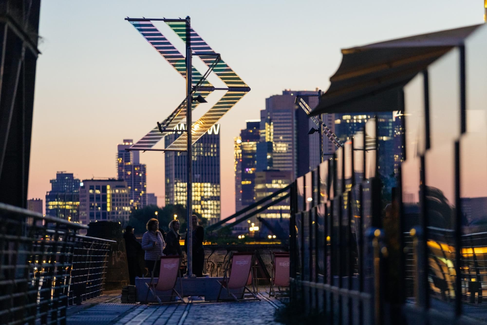 Mit der Frankfurter Skyline im Hintergrund sind 2 Solar-Beleuchtungen von Main-Light abgebildet.