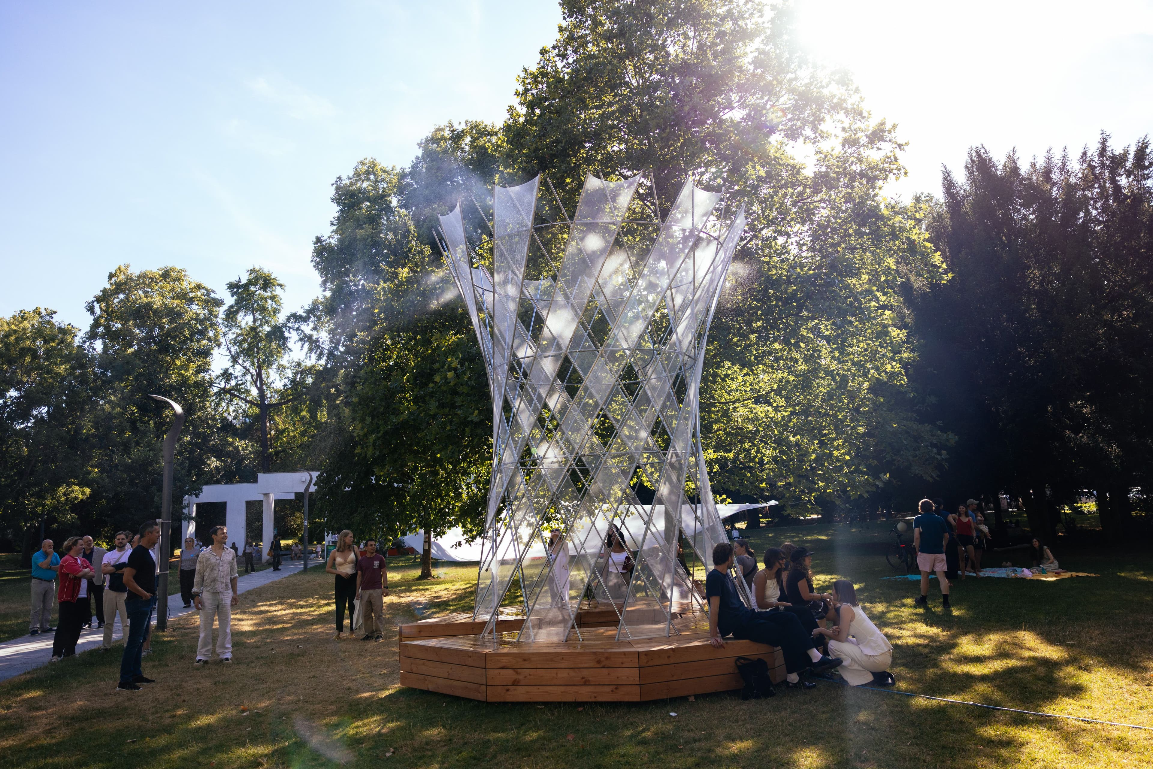 Ein wassersprühender Pavillon steht in einem grünen Park.