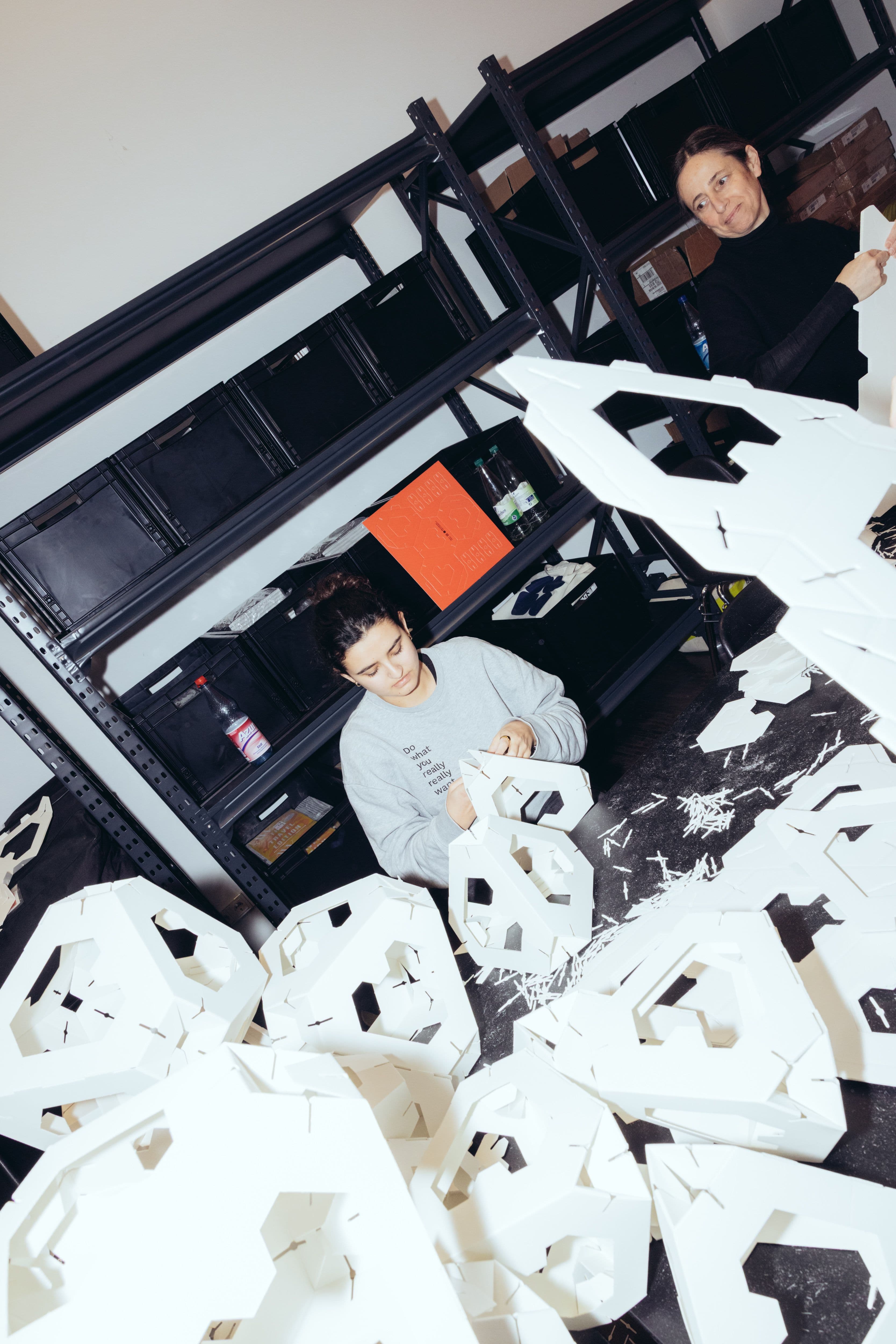 Eine junge Frau bastelt an der Papierinstallation Collective Paper Aesthetics