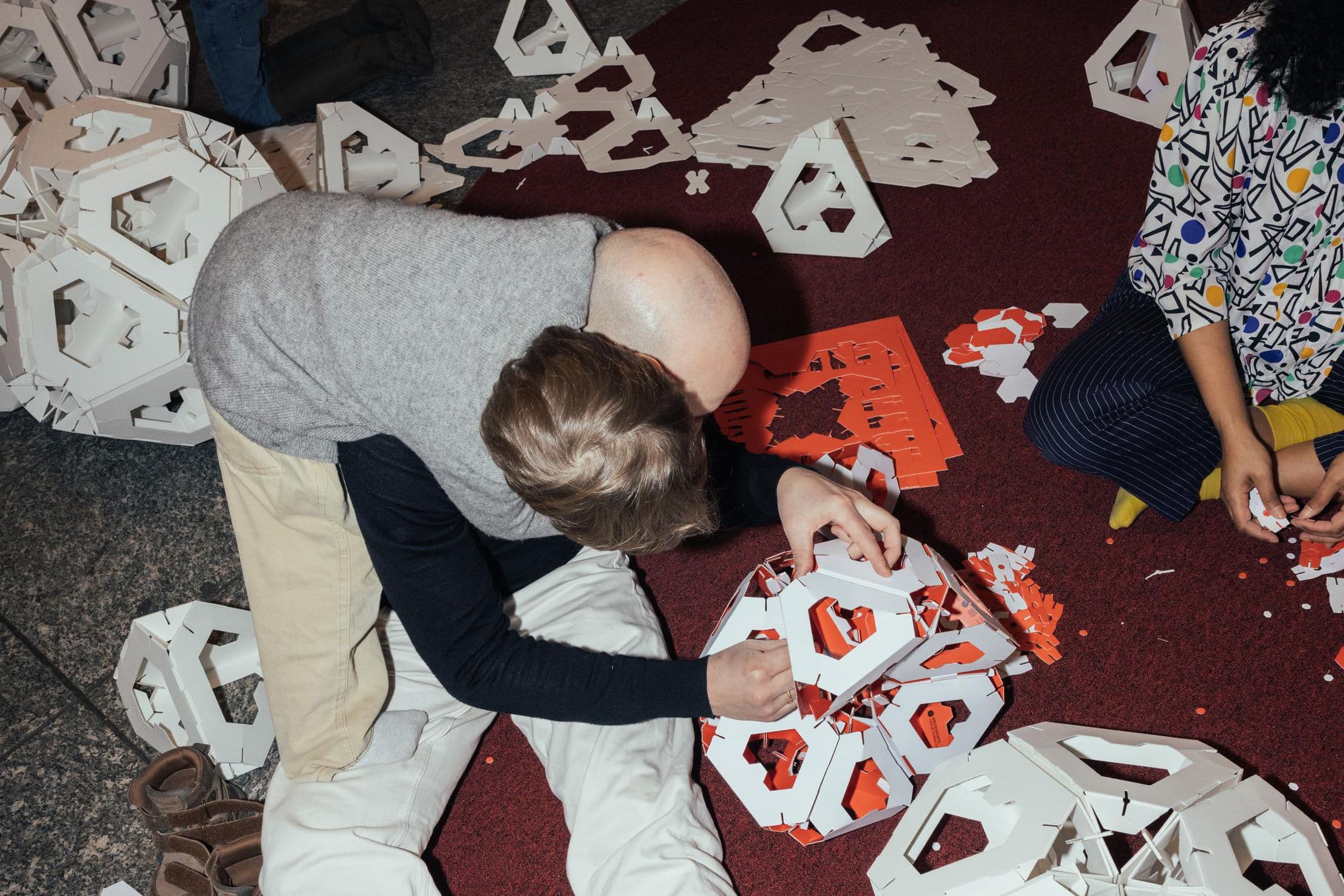 Menschen basteln an den Papierformen der Collective Paper Aesthetics im WDC Hub