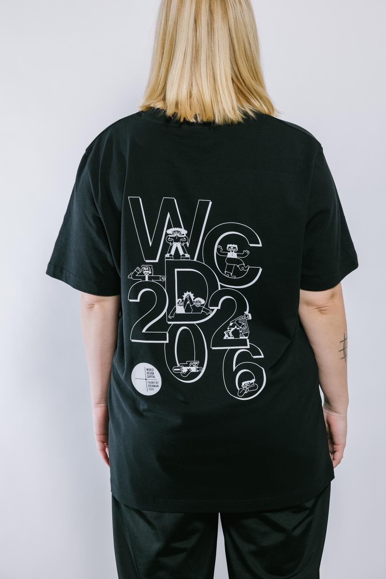 Eine Person trägt das WDC-Shirt und ist von hinten abgebildet. Dort sind die Illustrationen.