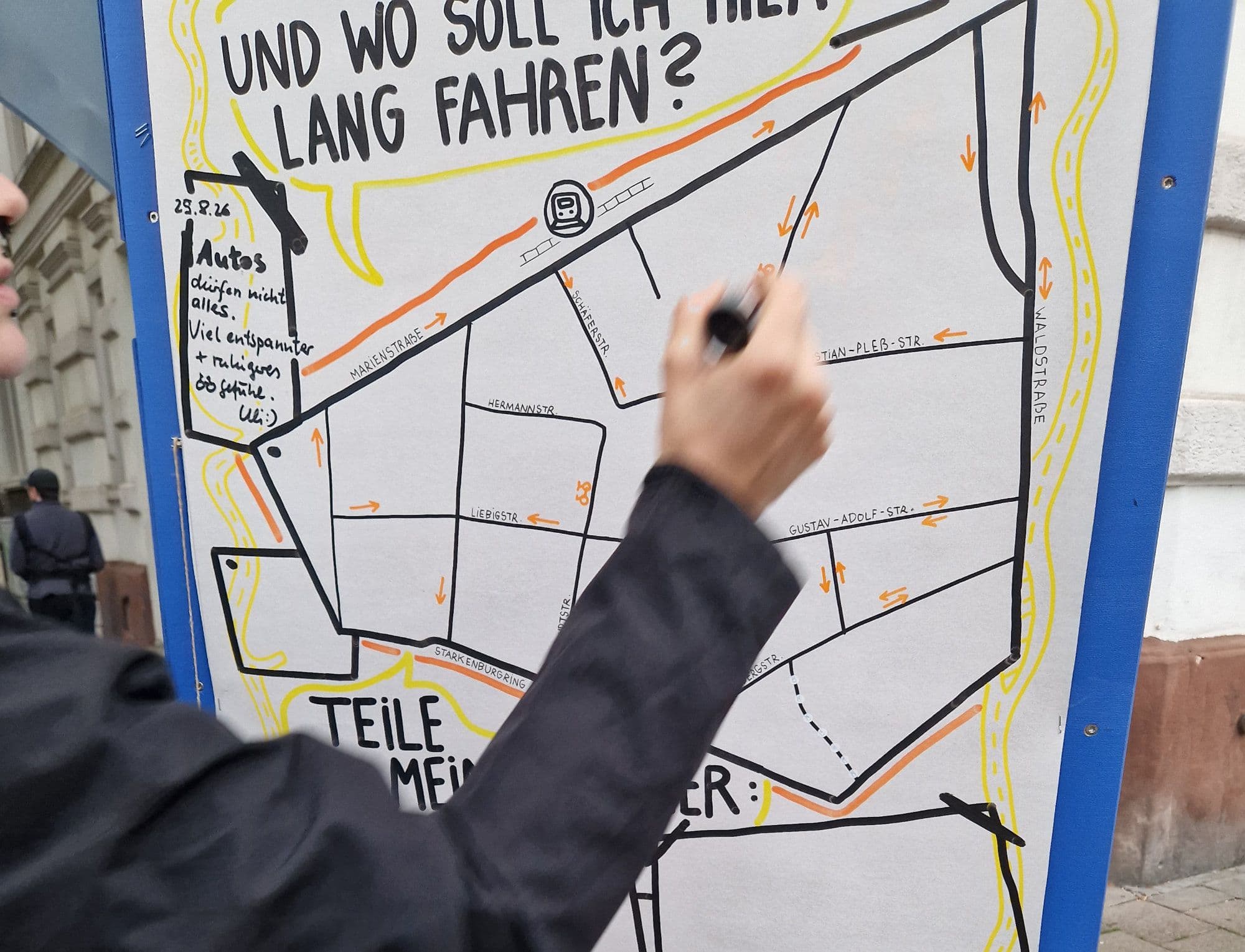 Eine Hand zeichnet etwas auf einen skizzierten Stadtplan