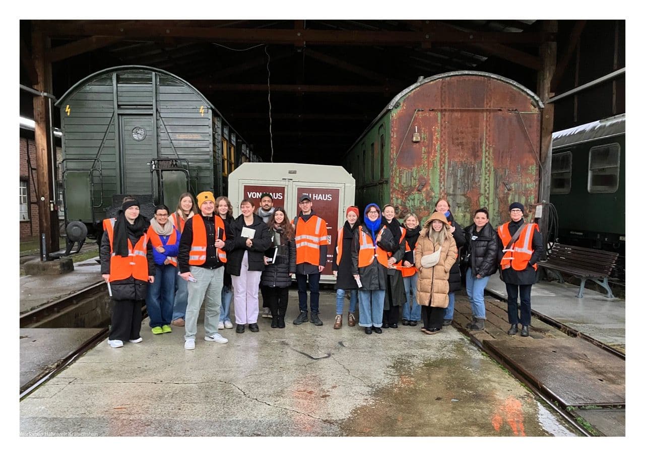 Schüler der Hochschule Darmstadt stehen vor Zugwagons 