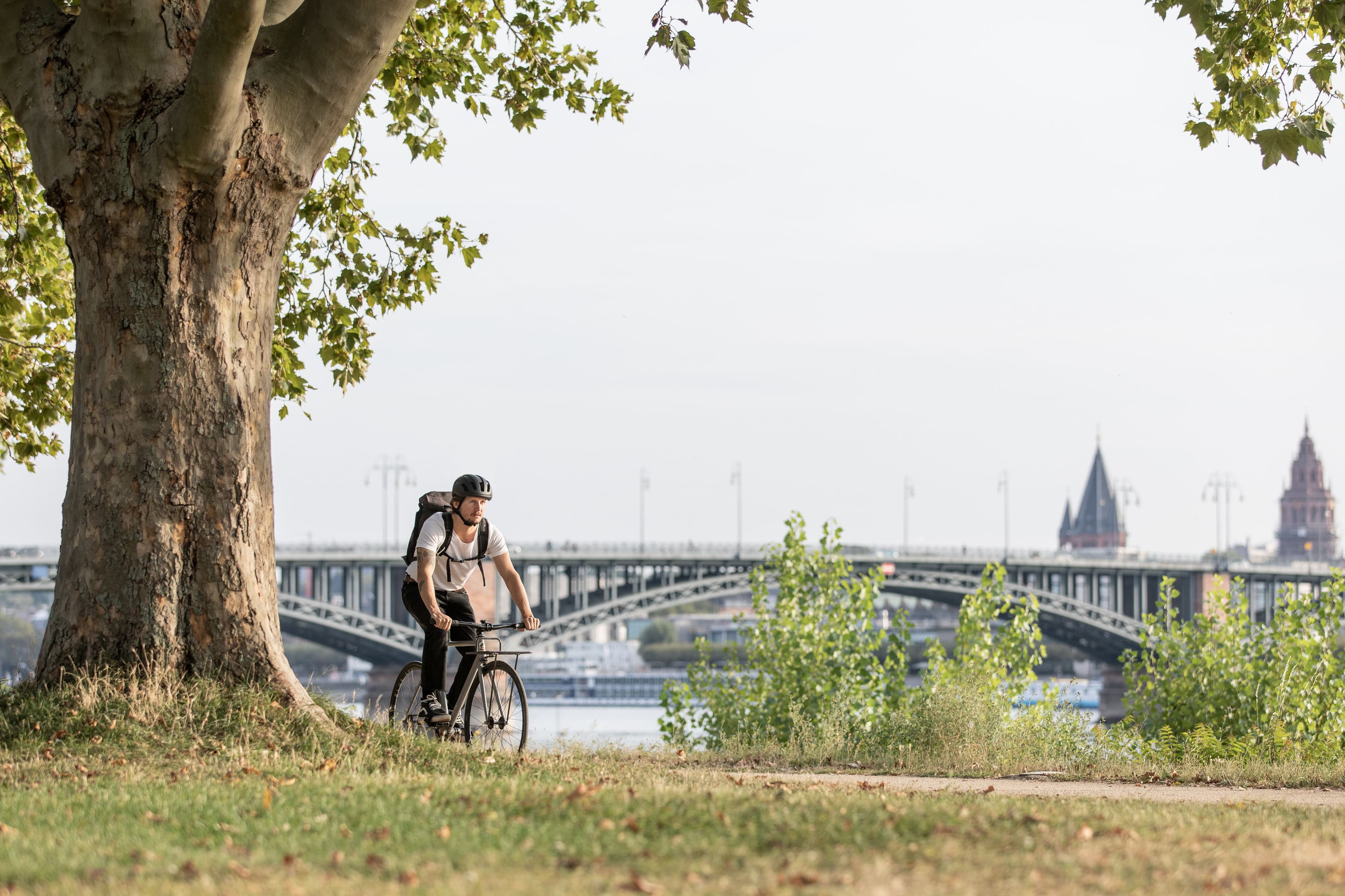 Ein junger Mann fährt mit seinem Fahrrad am Rheinufer in Wiesbaden