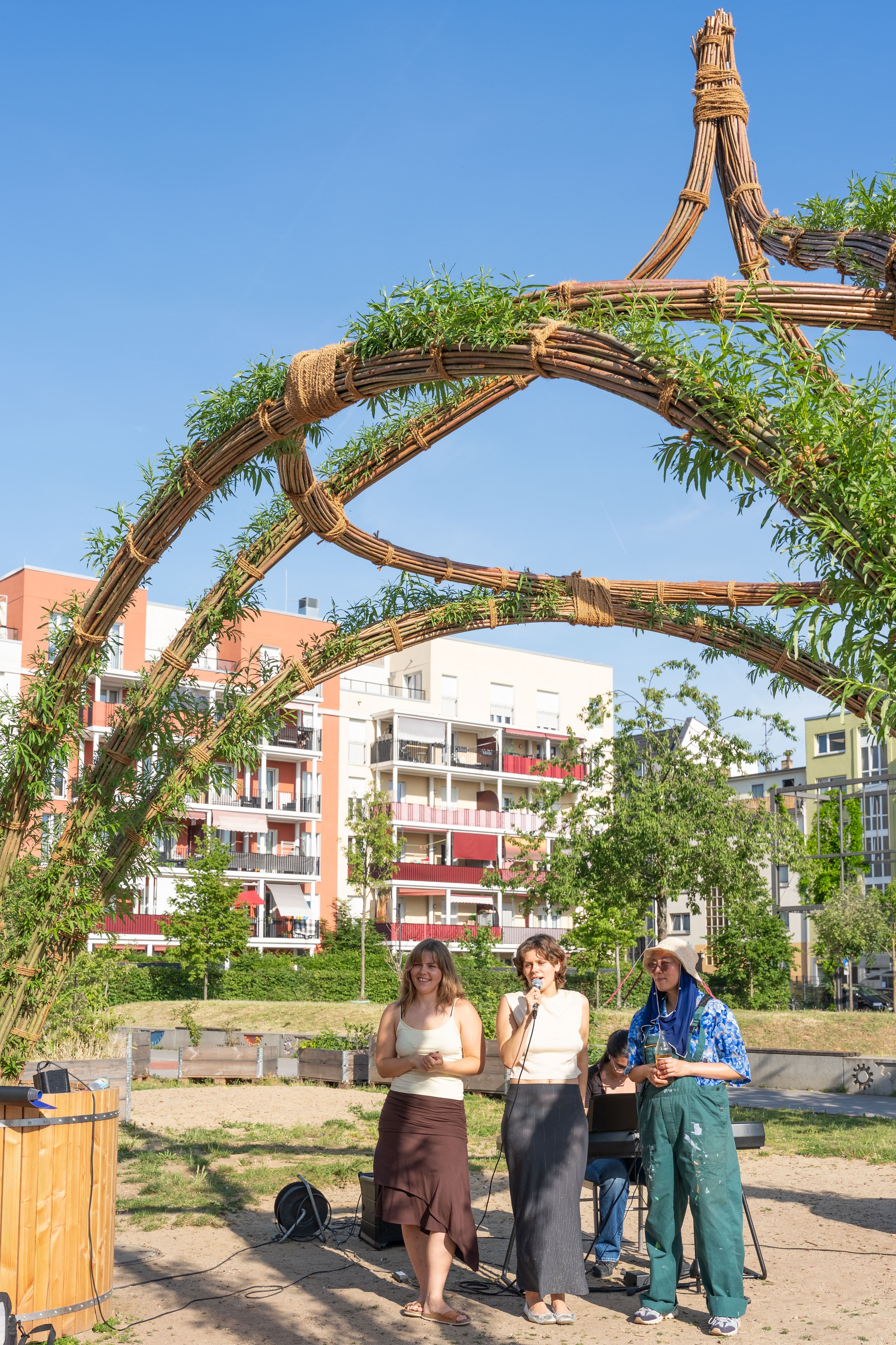 Personen stehen unter dem Weidenpavillon