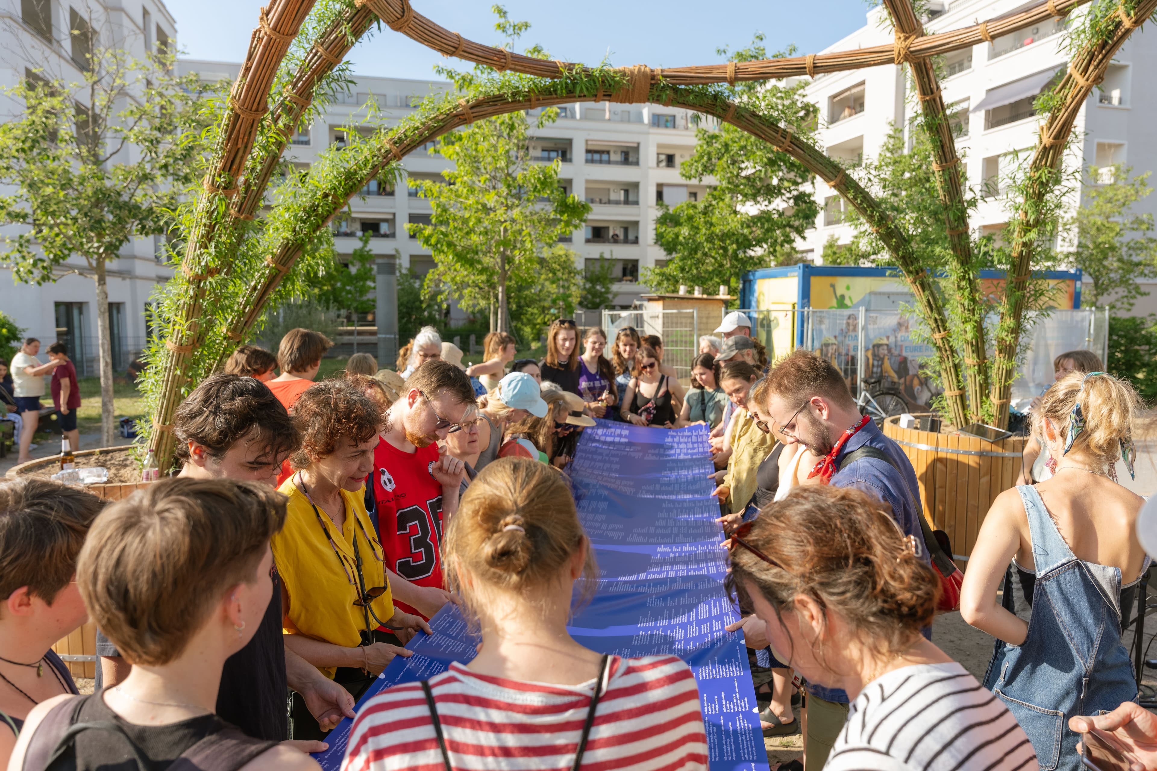 Mehrere Menschen stehen zusammen unter dem Weidenpavillon