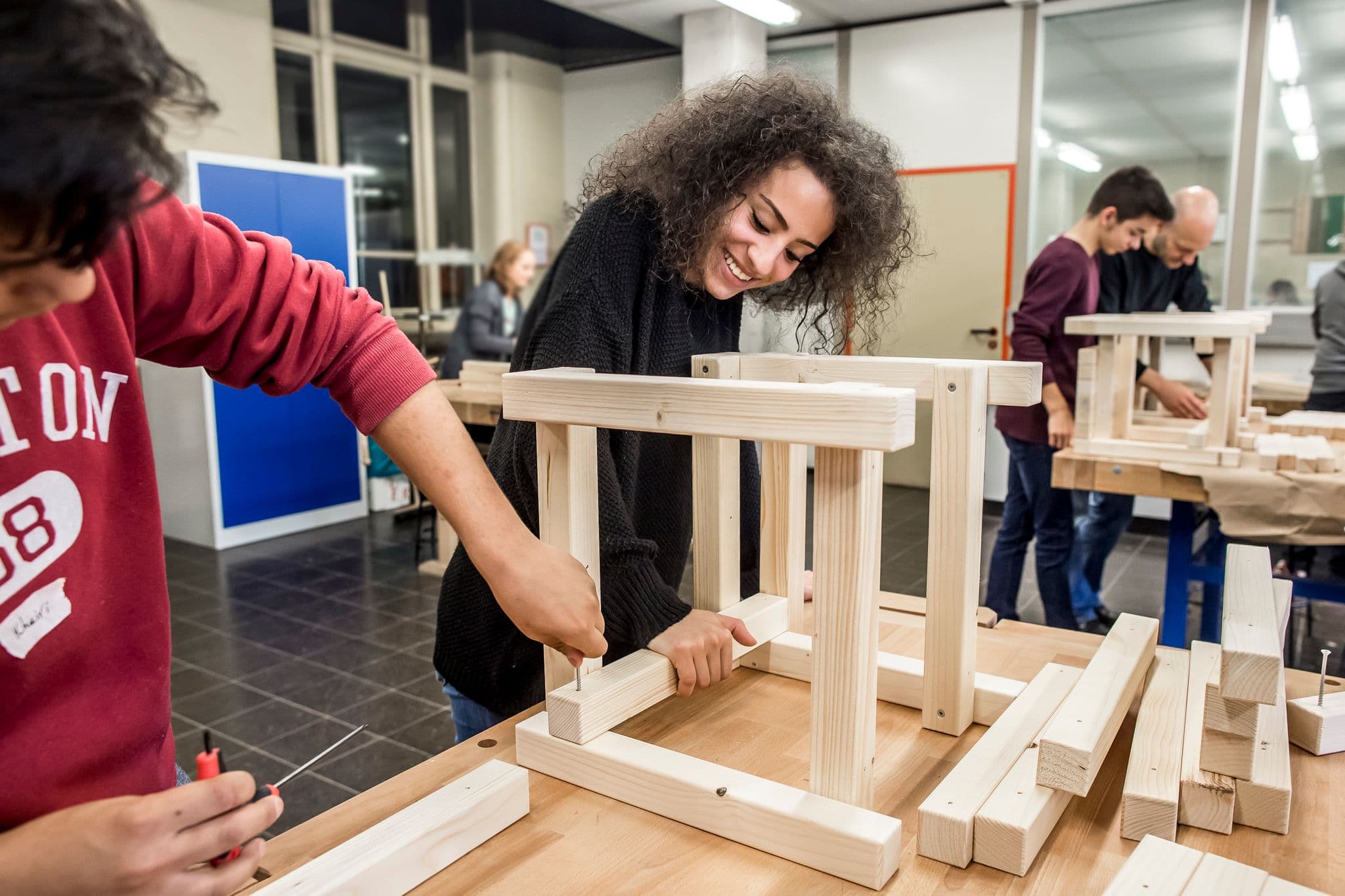Eine Frau baut an einem Möbel aus Holz