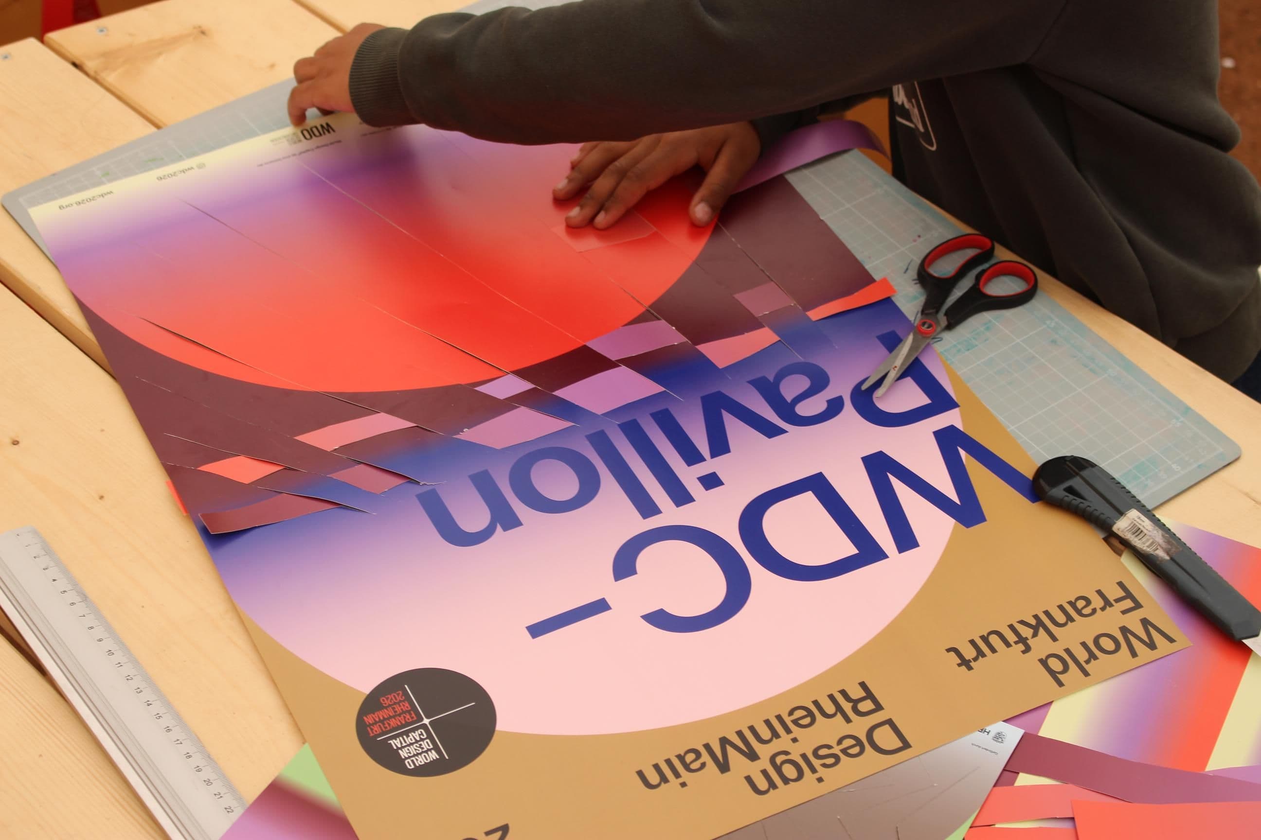 Zwei Hände basteln an einem Plakat