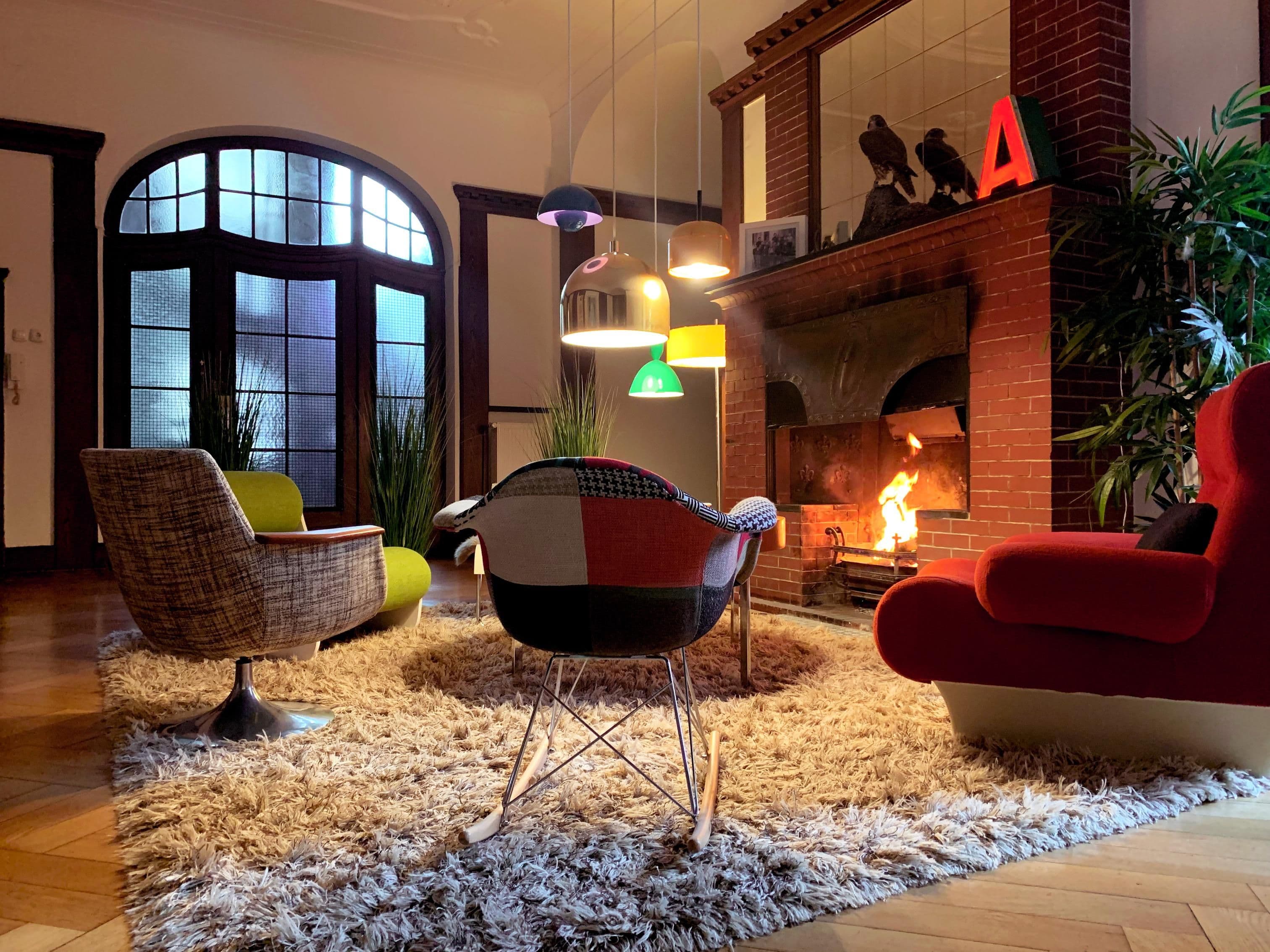 Stuhle stehen in einem großzügigen Zimmer vor einem Kamin