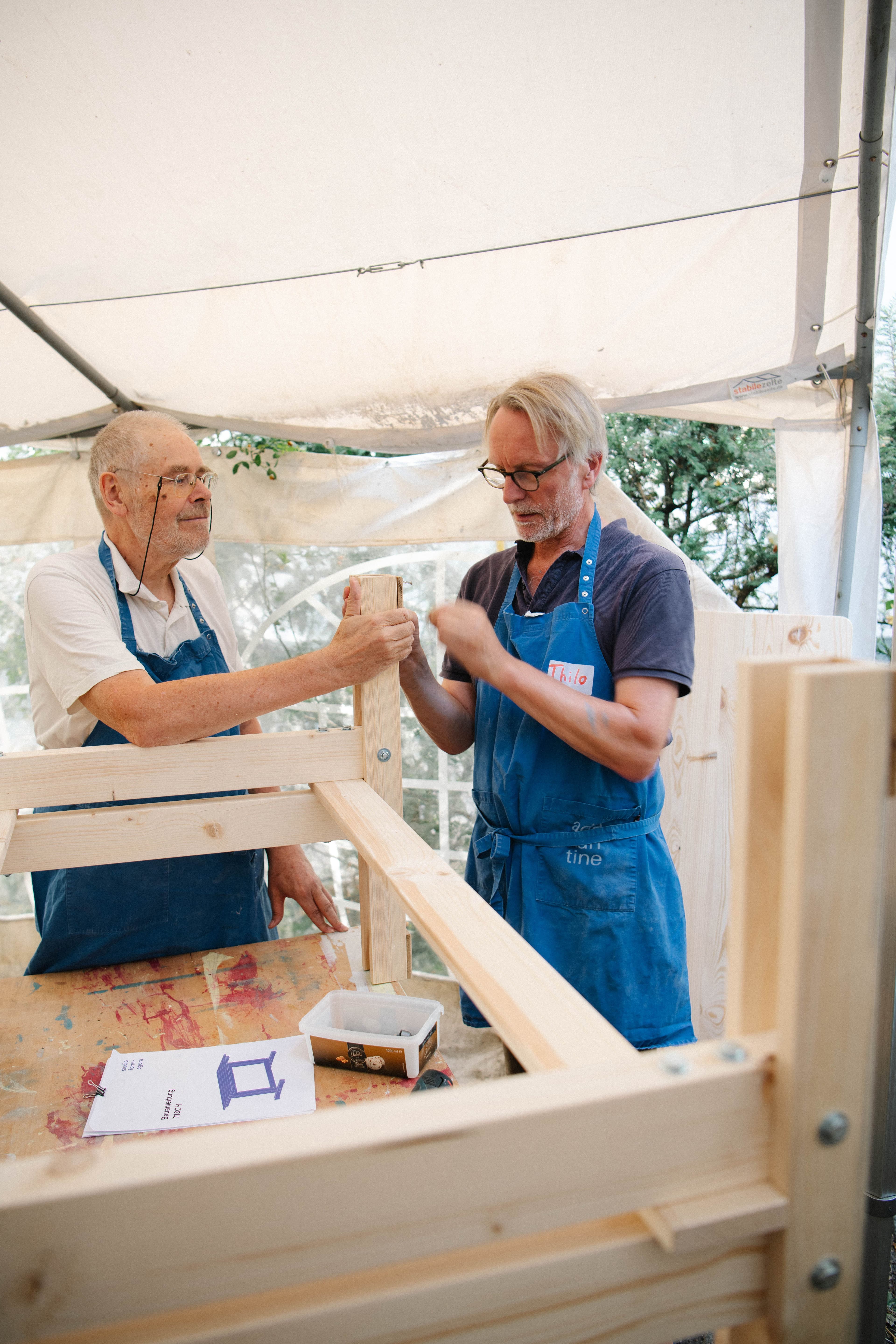 Zwei Männer arbeiten gemeinsam mit Holz