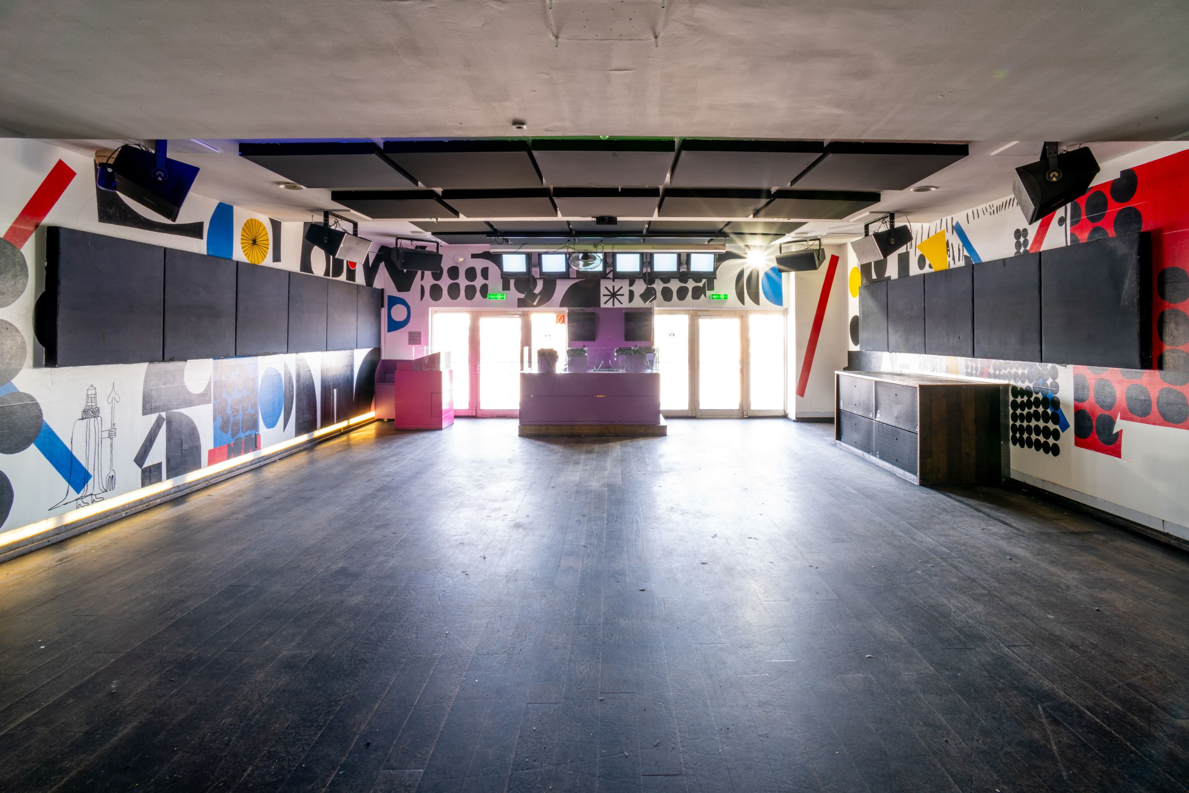 Ein Club mit bunten Wandbemalungen und Fenstern.