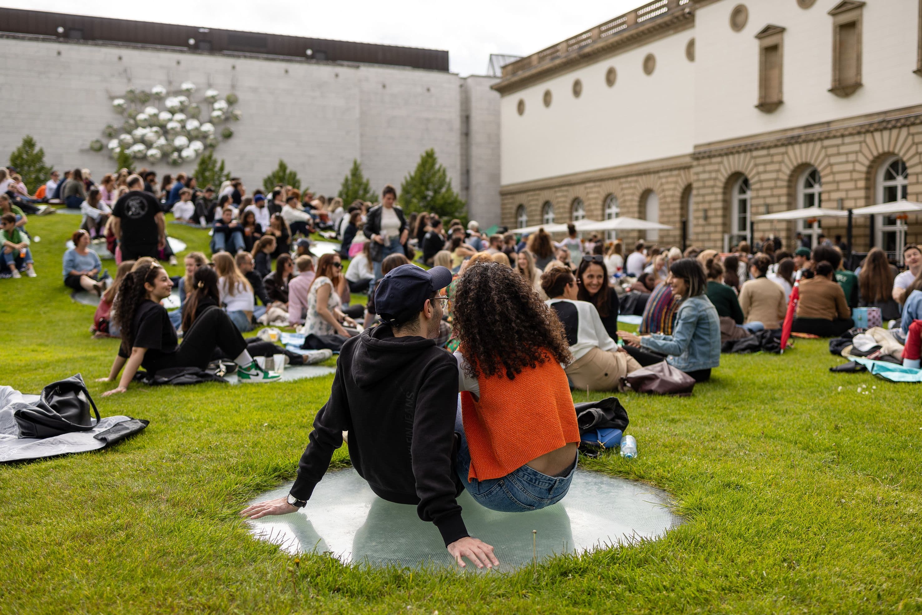 Menschen sitzten gemeinsam auf der Wiese im Innenhof des Städel Museums