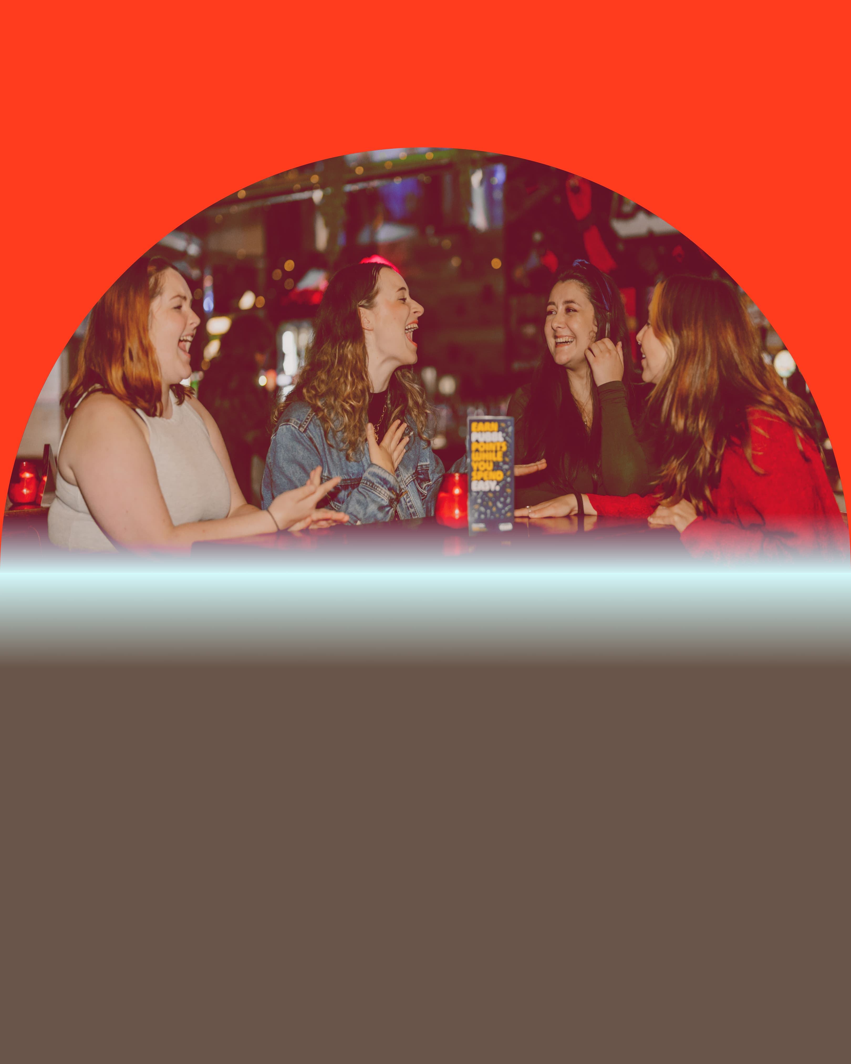 Menschen am Tisch lachen gemeinsam in Bar-Atmophäre
