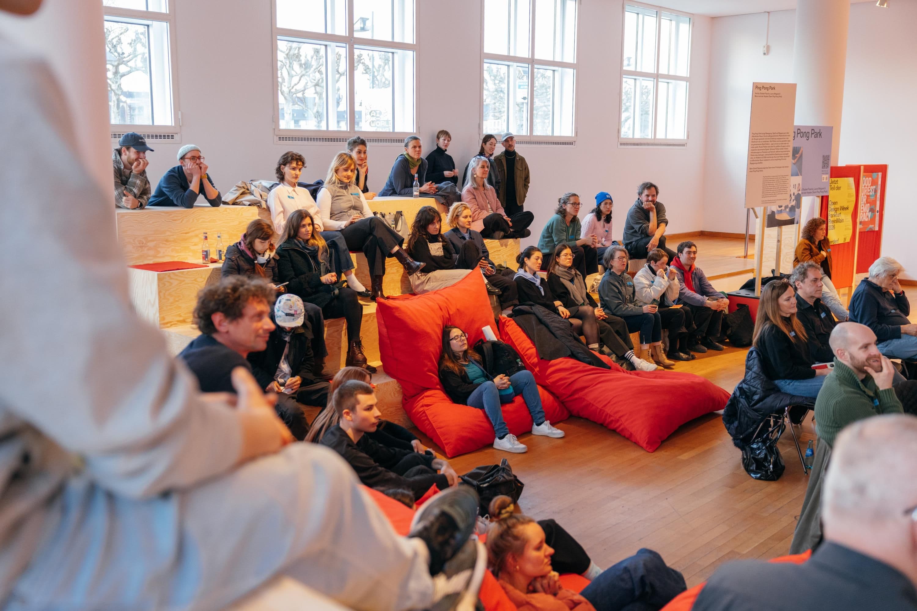 Viele Personen sitzen in einem hellen großen Raum
