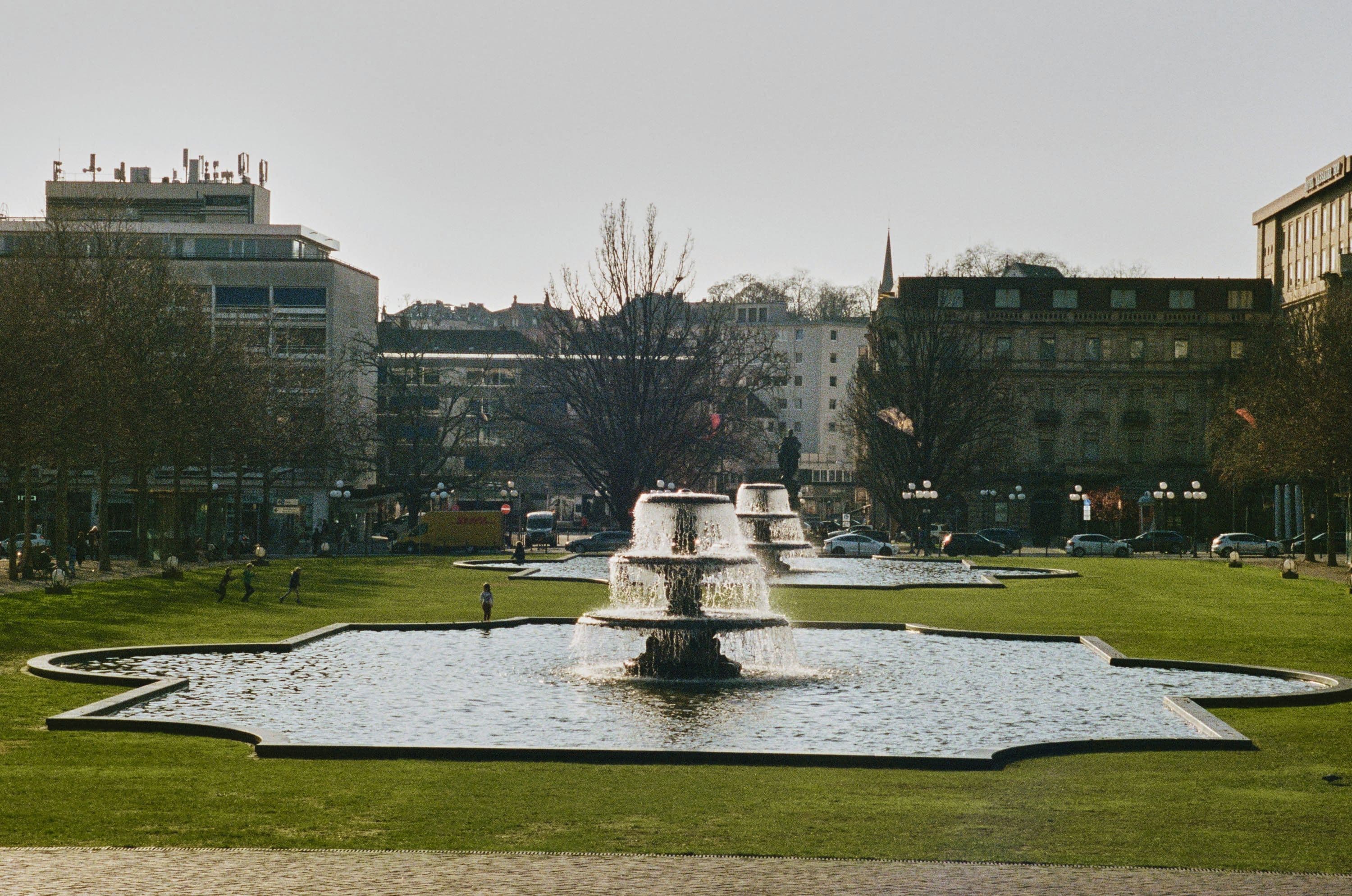 Blick auf einen Brunnen in einer grünen Parkanlage