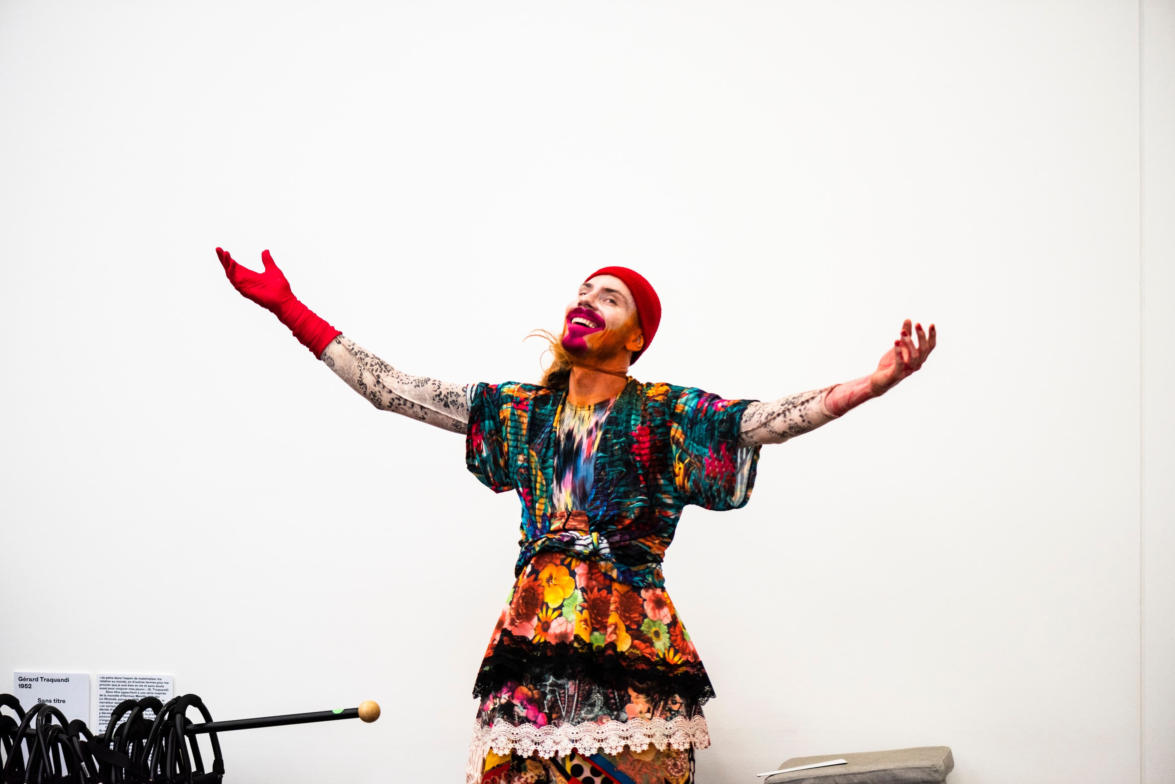Bild von einer bunt gekleideten Person und orangenem Bart. Stillfoto der Performance Outrar