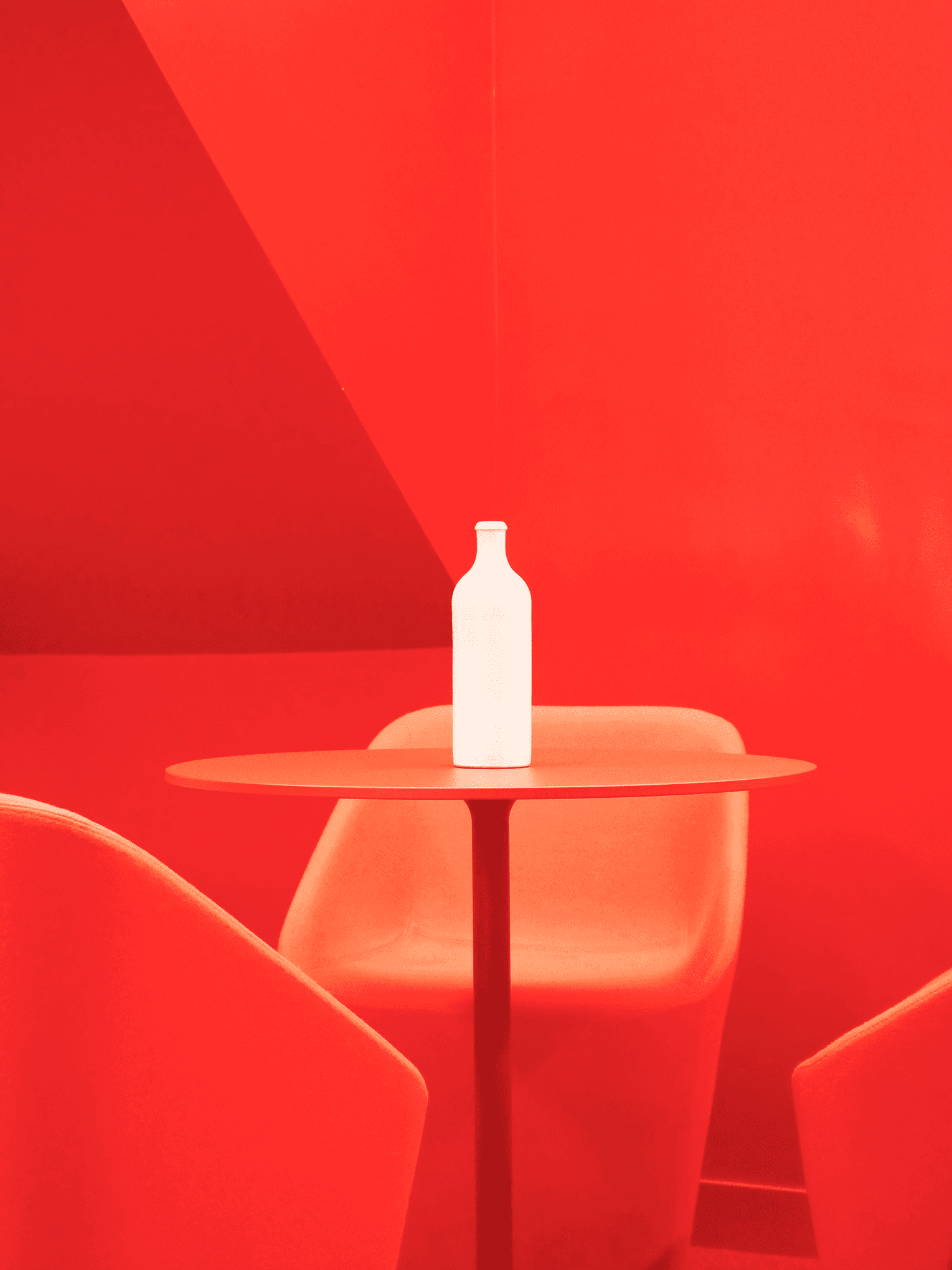 eine weiße Flasche steht auf einem Tisch in einem roten Raum