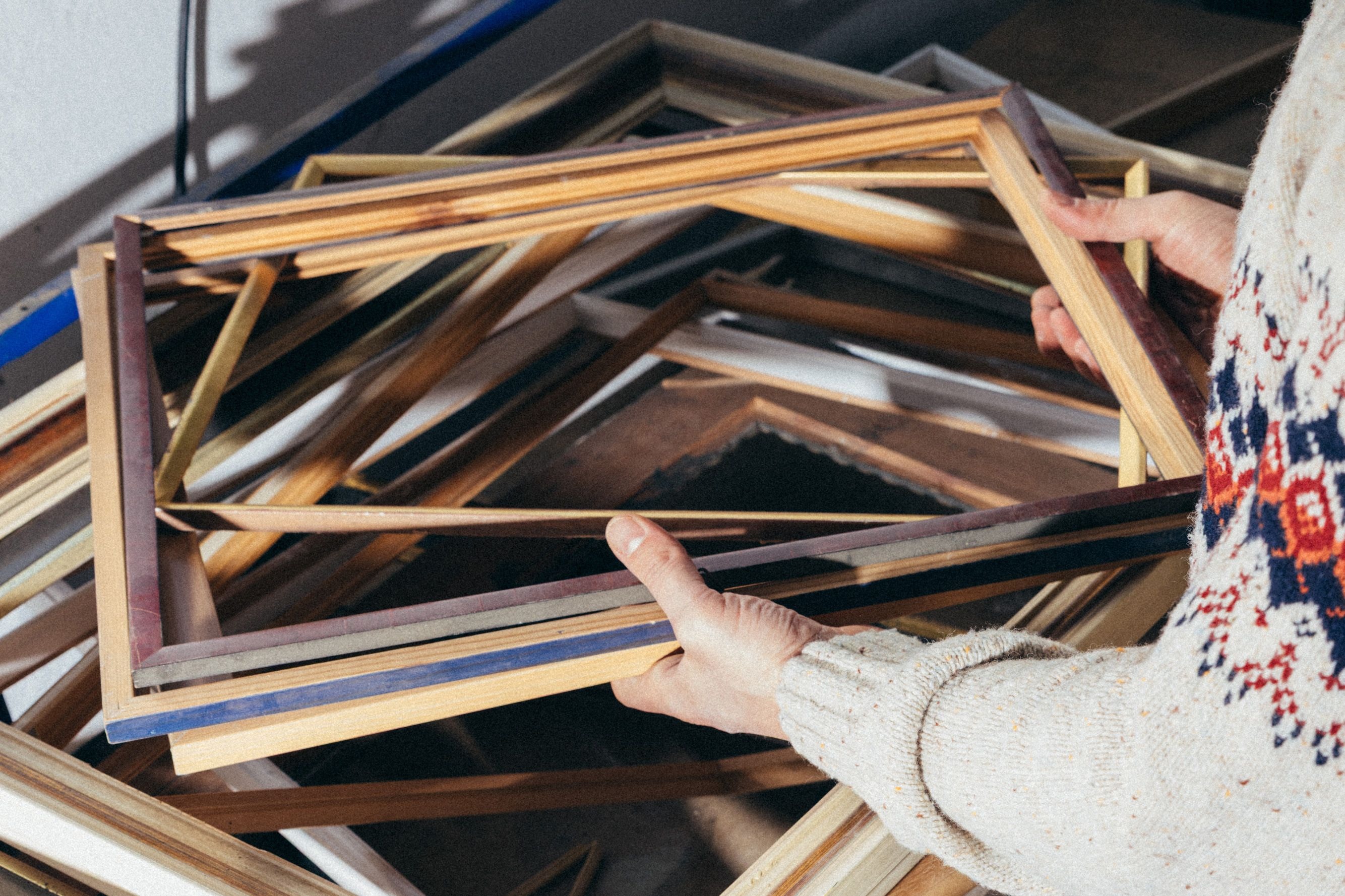 Felix Große-Lohmann zieht einen Bilderrahmen aus dem Fundus von Material für Alle