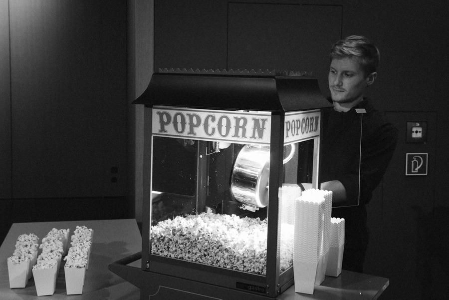 Ein junger Mann bedient eine Popcornmaschine.