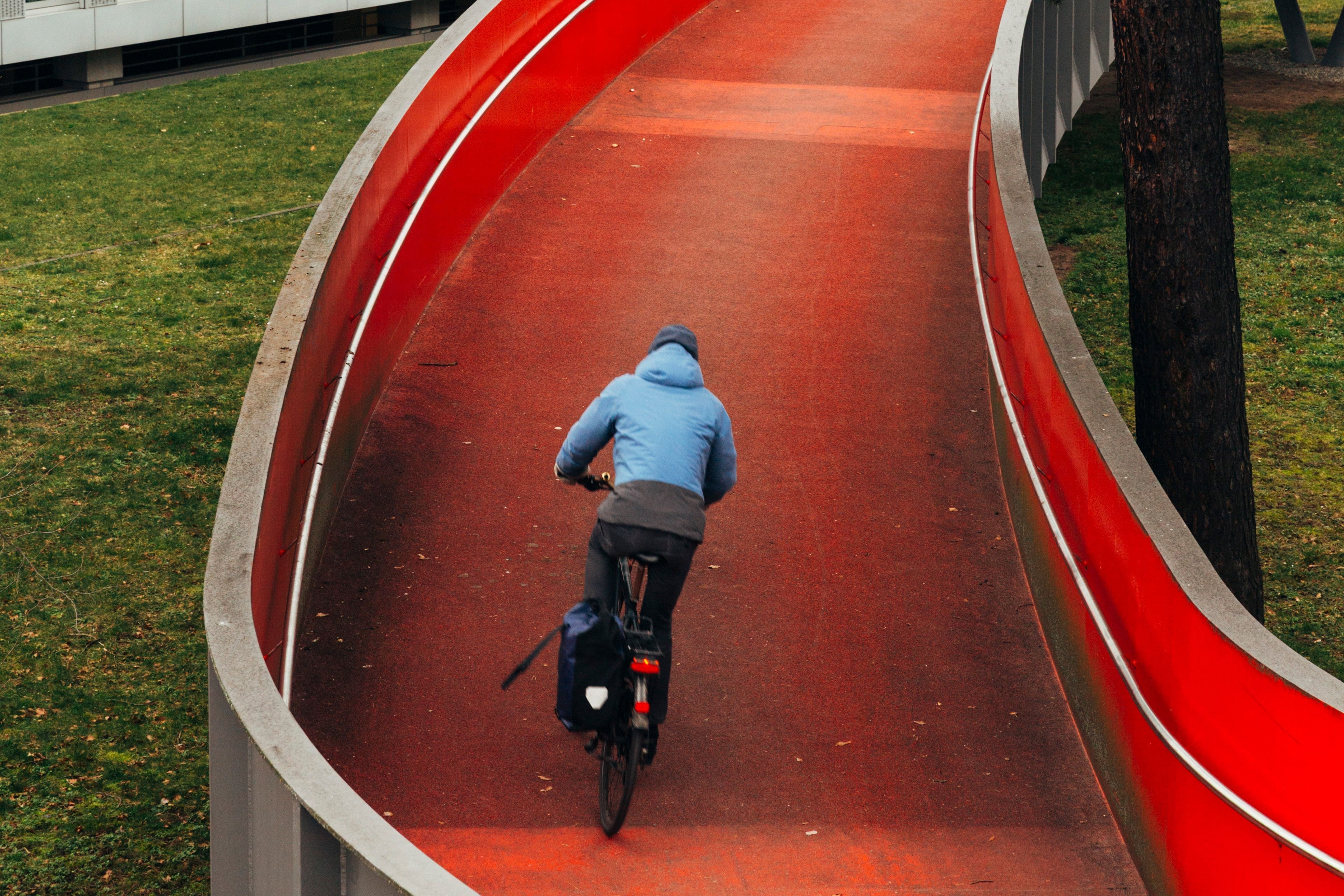 Ein Fahrradfahrer fährt über eine rote Brücke