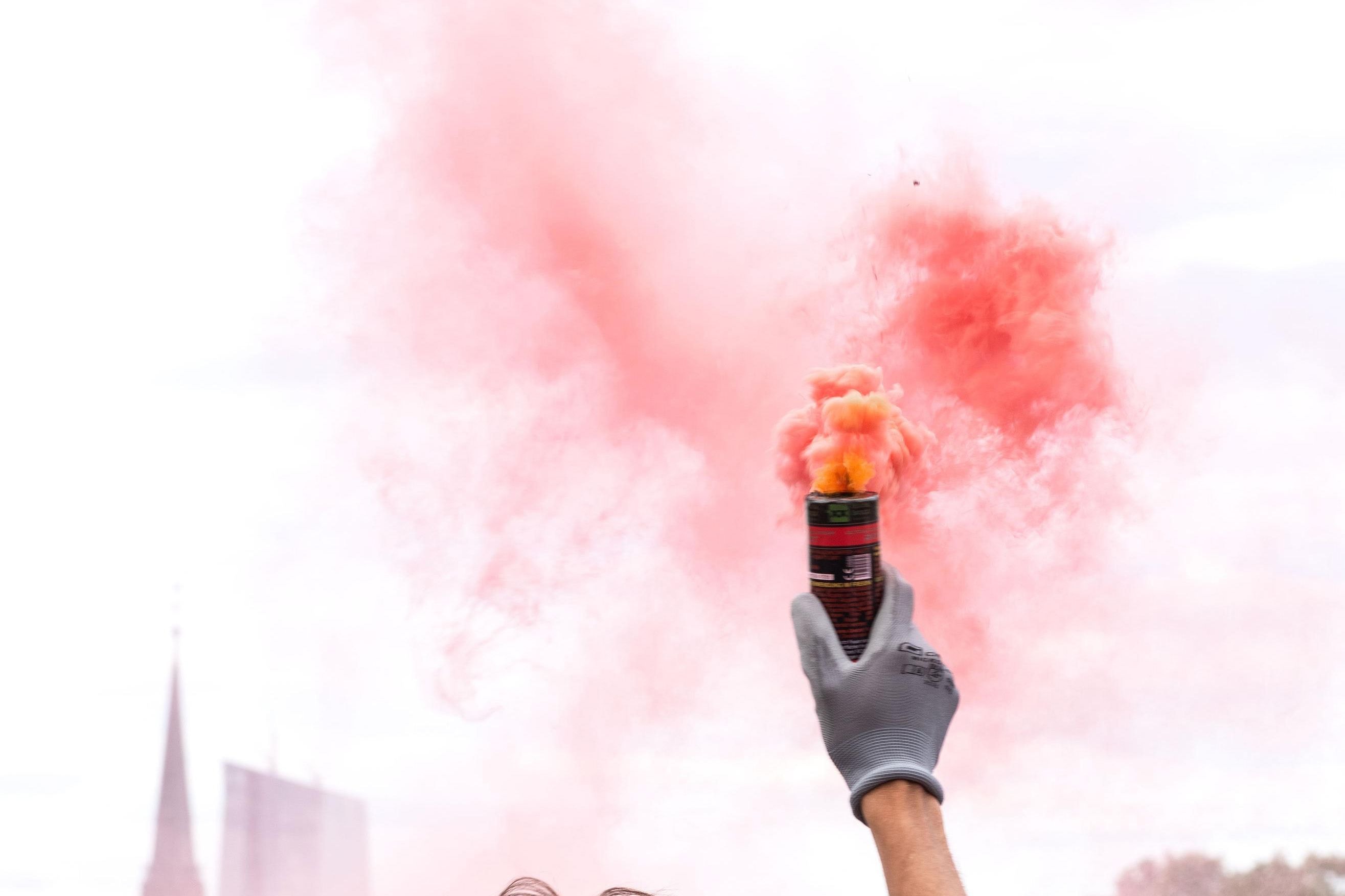 Eine rote Rauchfackel wird in den Himmel gehalten
