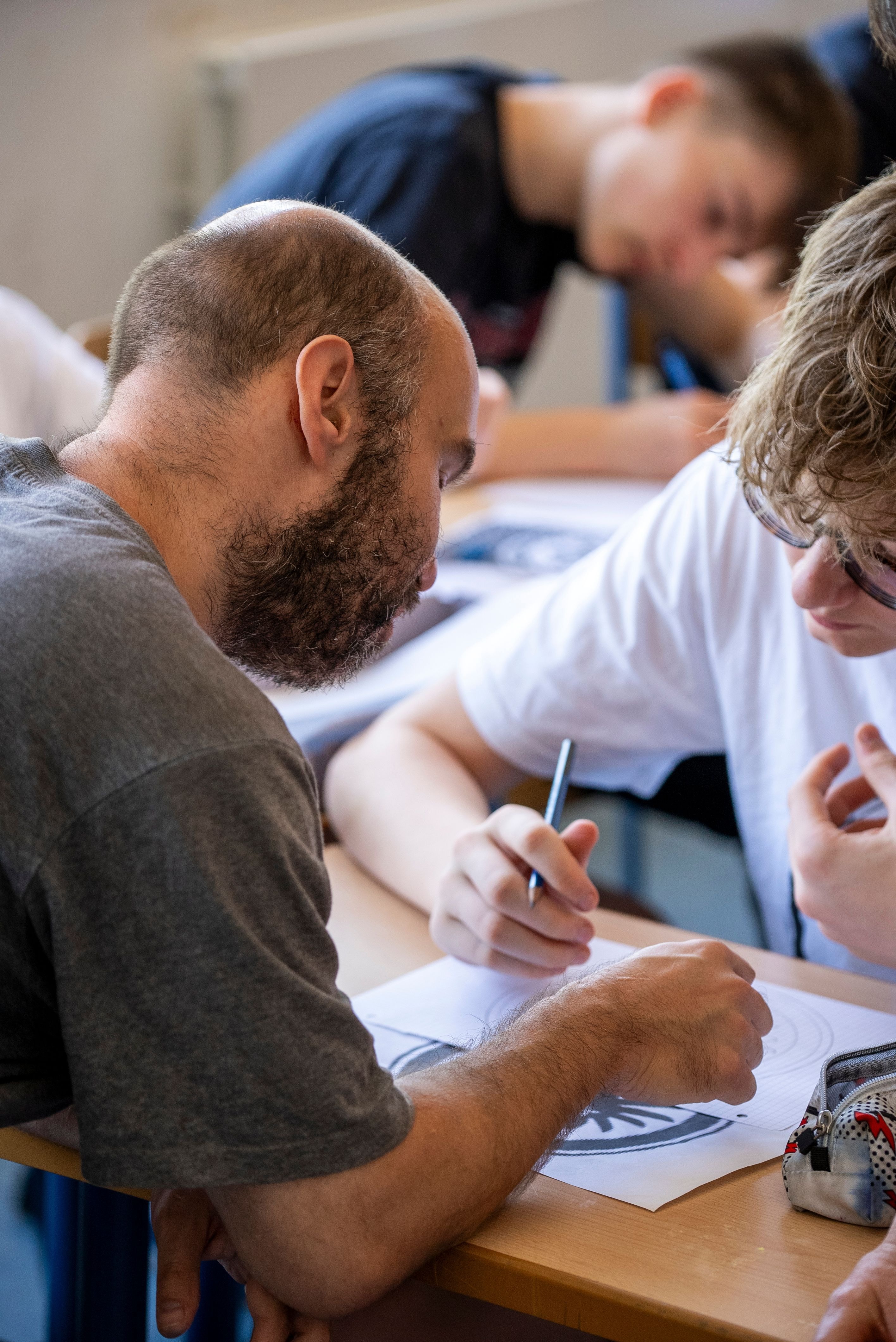 Zwei Menschen arbeiten gemeinsam an einem Bild