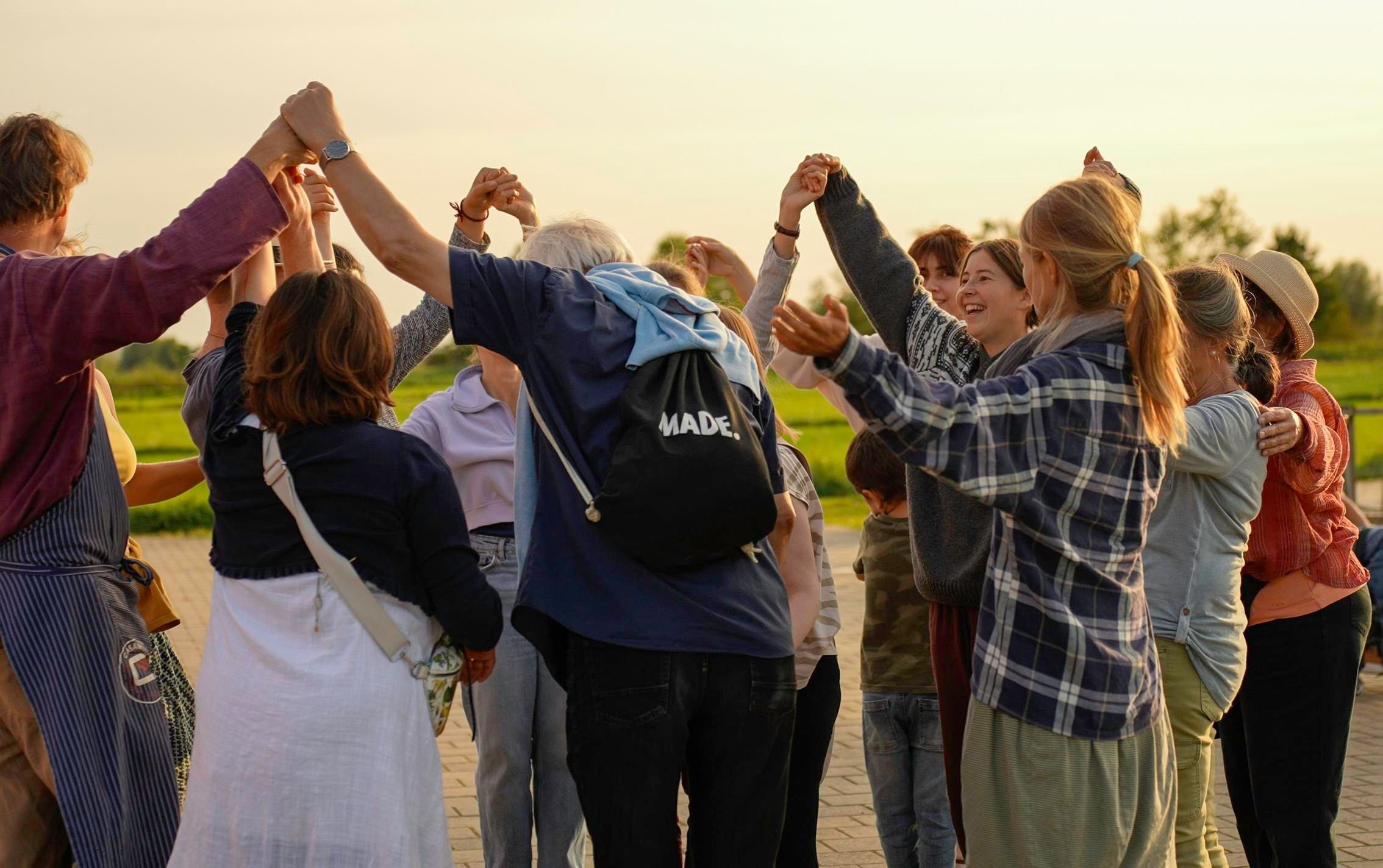 Menschen stehen zusammen und heben die Arme in die Luft