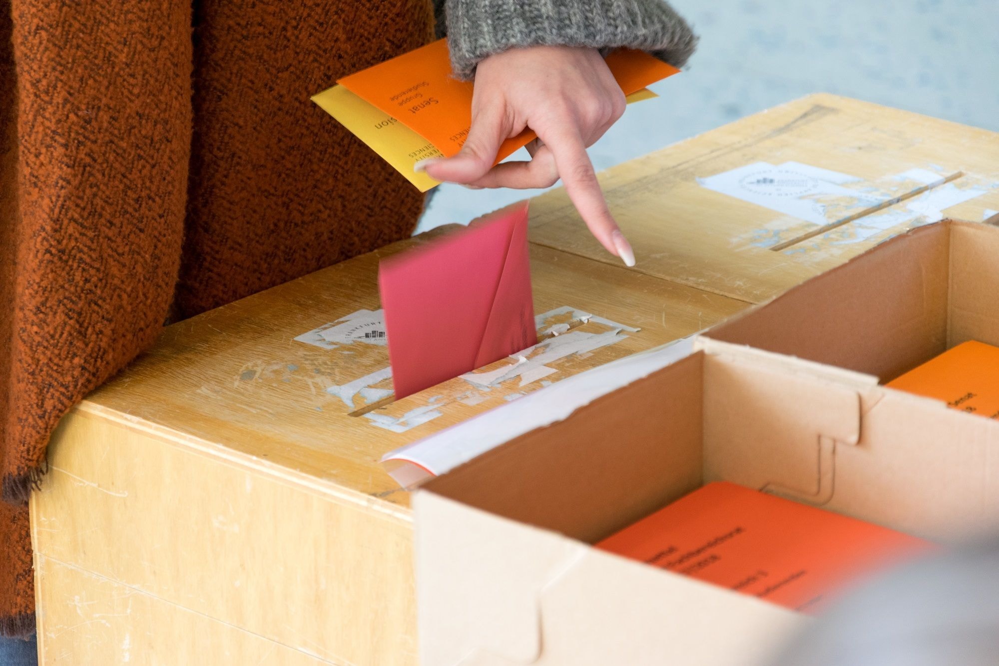 Frau legt ihren Wahlbogen in die Wahlurne 