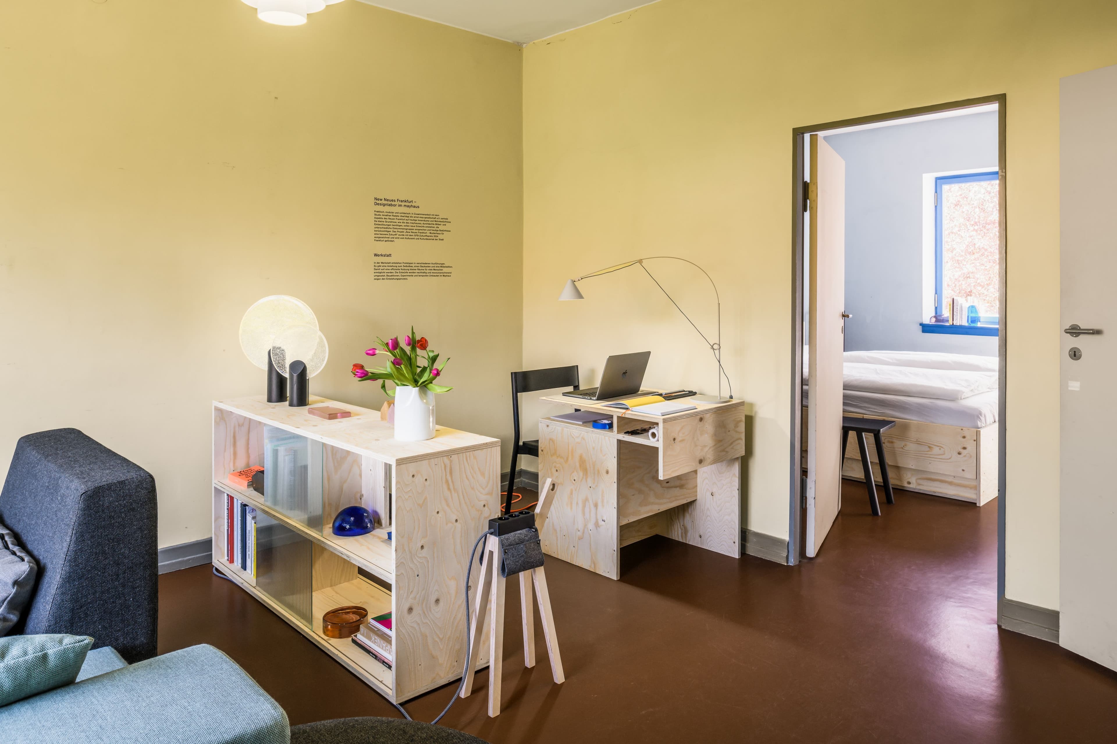 Bild der Ausstellung, zu sehen ist ein Holztisch und eine Holzkommode