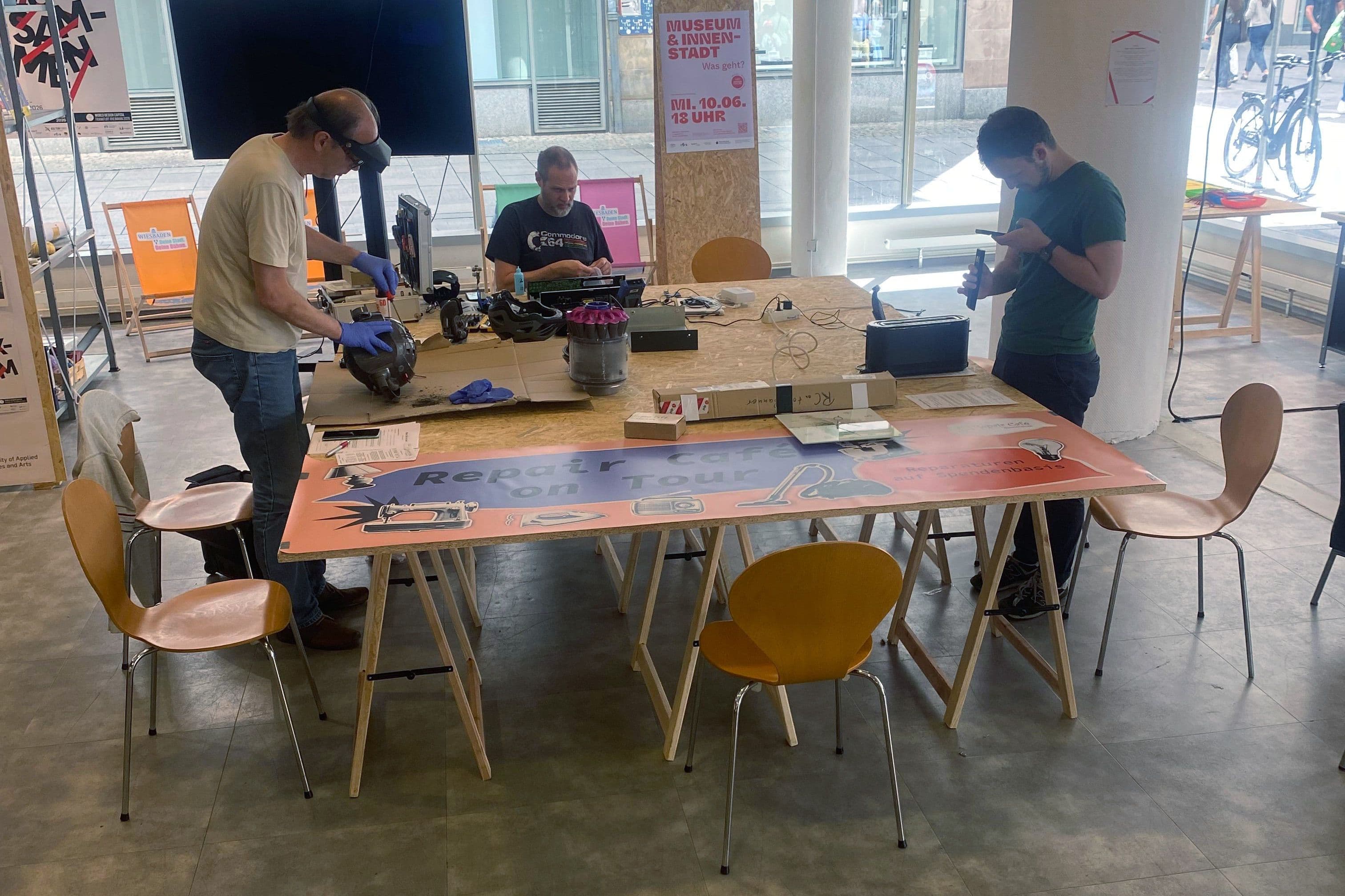 Menschen arbeiten und reparieren im Rahmen des Repair Cafes im Werkraum Wiesbaden