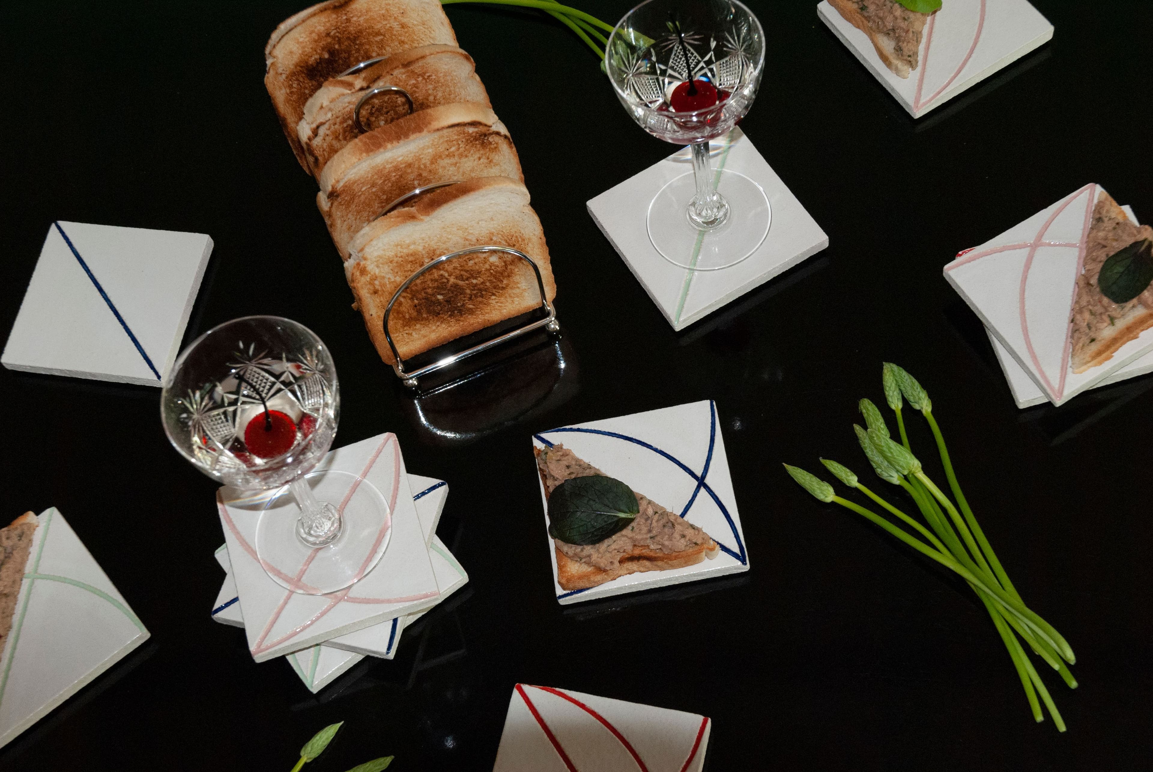 Auf einem Tisch stehen Toast, Gläser und Untersetzer