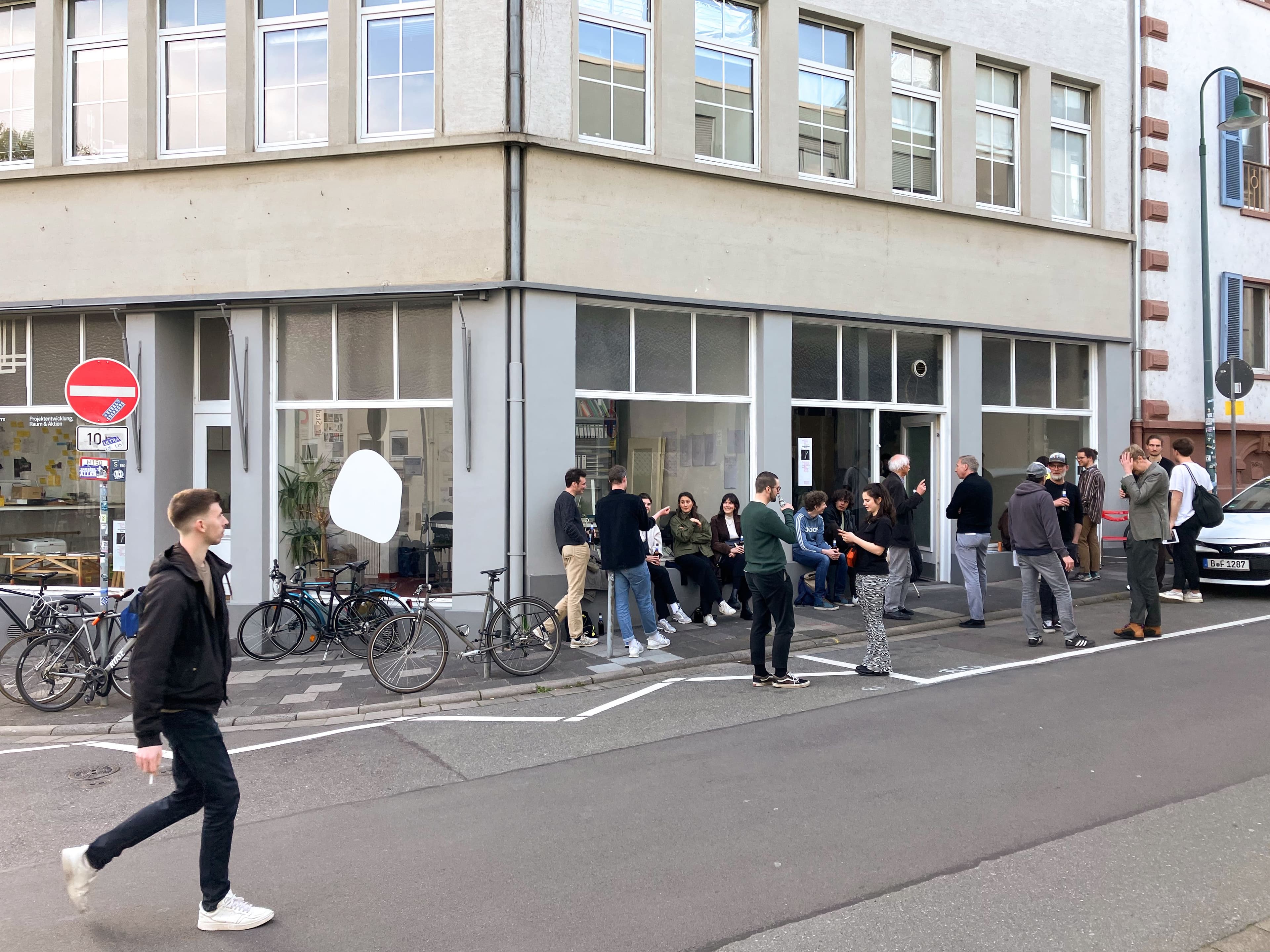 Menschen stehen vor einem Gebäude und unterhalten sich