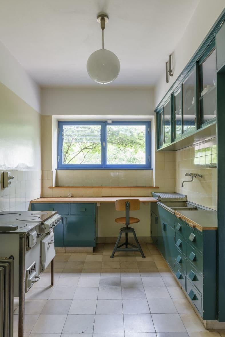 Frankfurter Küche im Mayhaus mit blauen Fensterrahmen und alten Holzmöbeln.