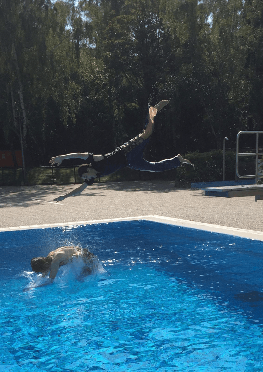 Eine Person springt kopfüber in einen Pool