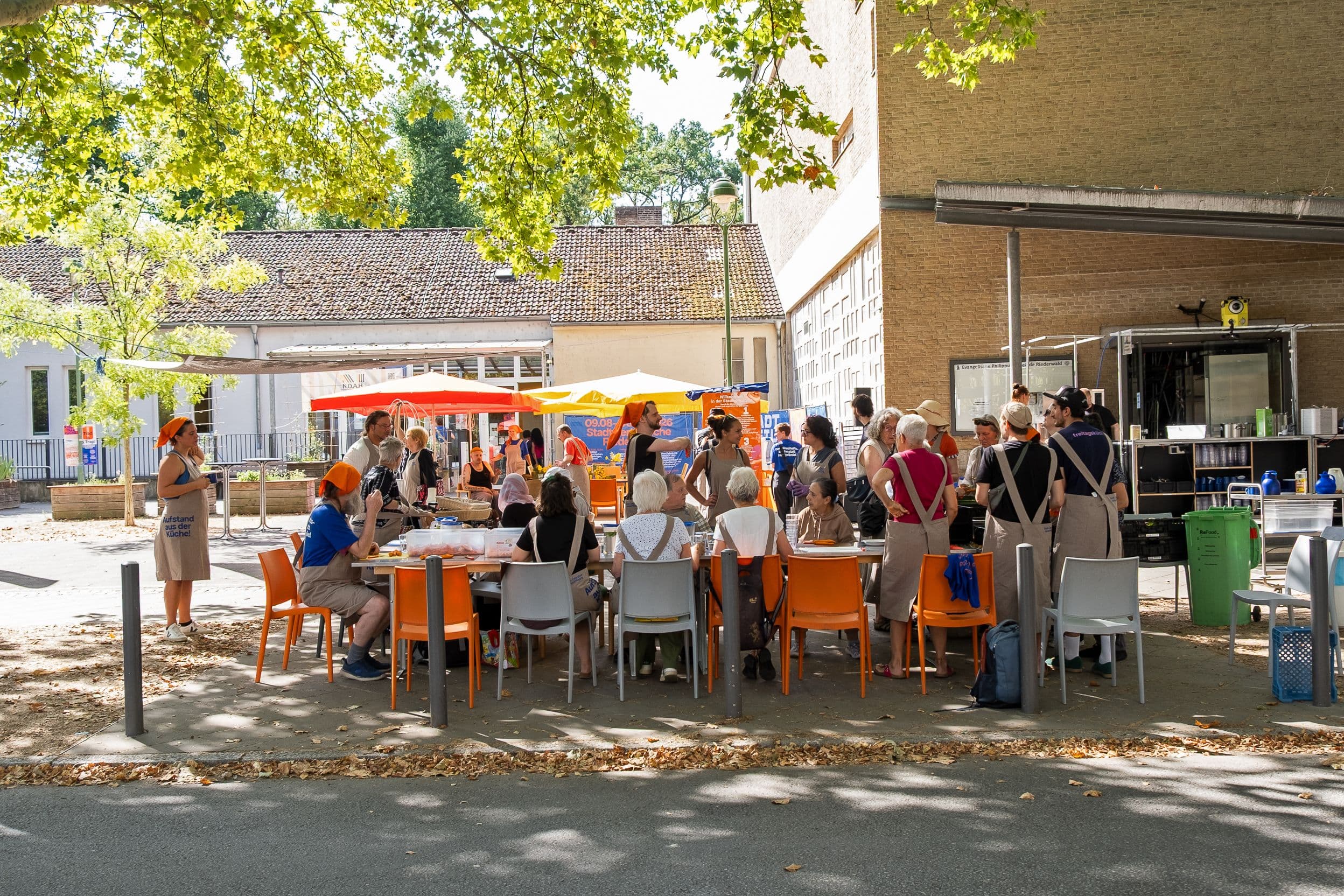 Viele Menschen sitzen zusammen am Tisch und essen.