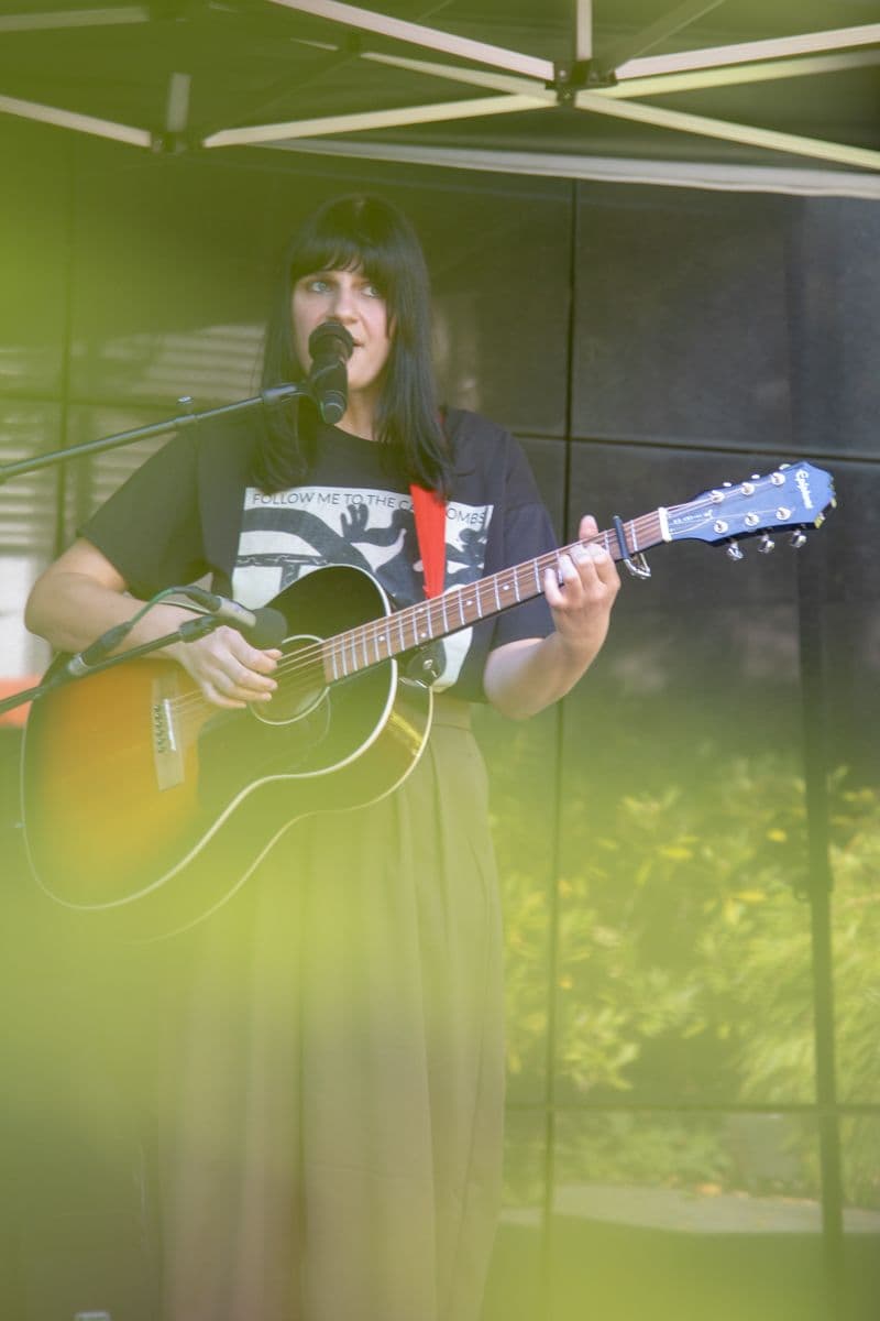 Eine Person mit Gitarre auf der Bühne