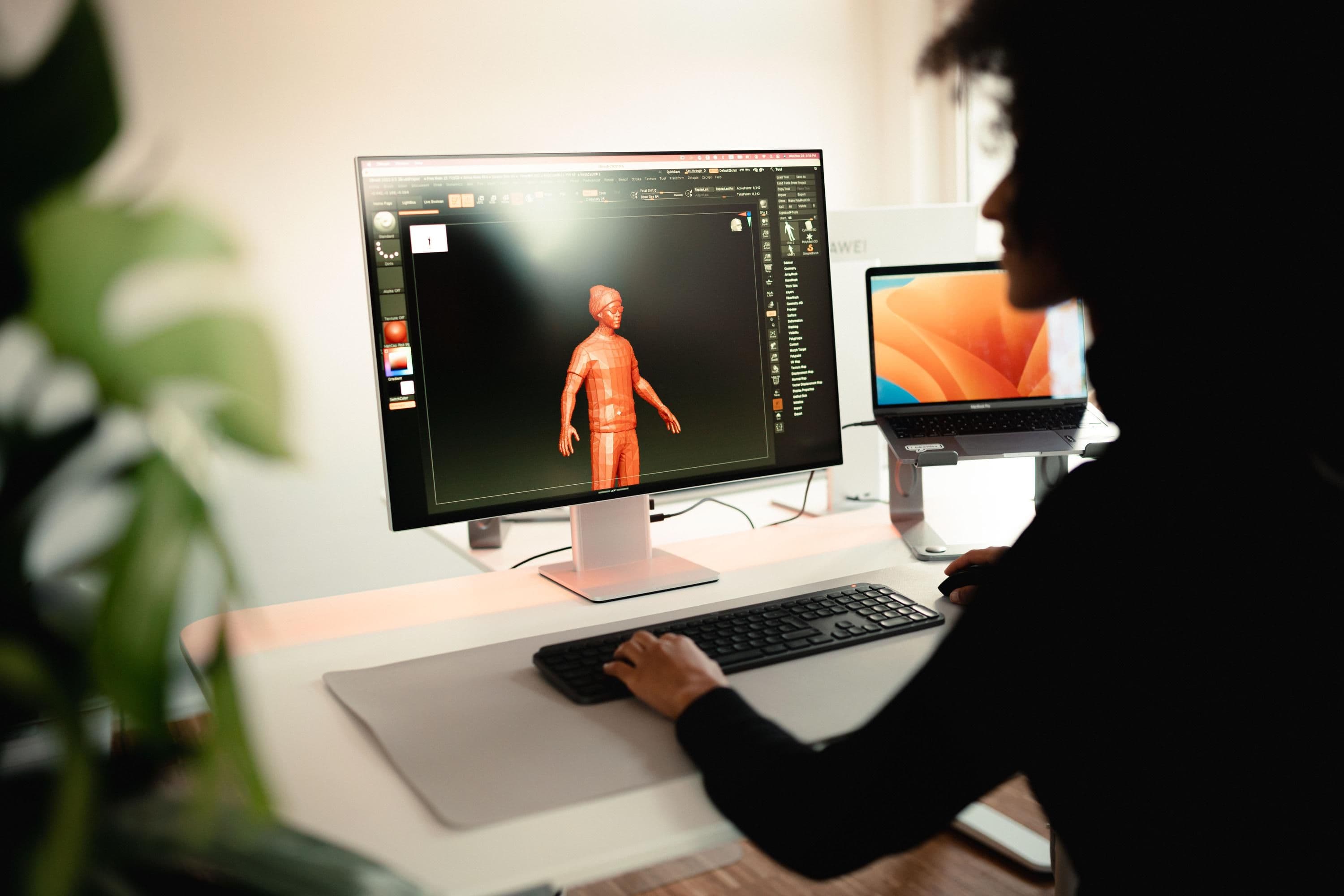 Eine Person sitzt vor einem Monitor und arbeitet an Visuals