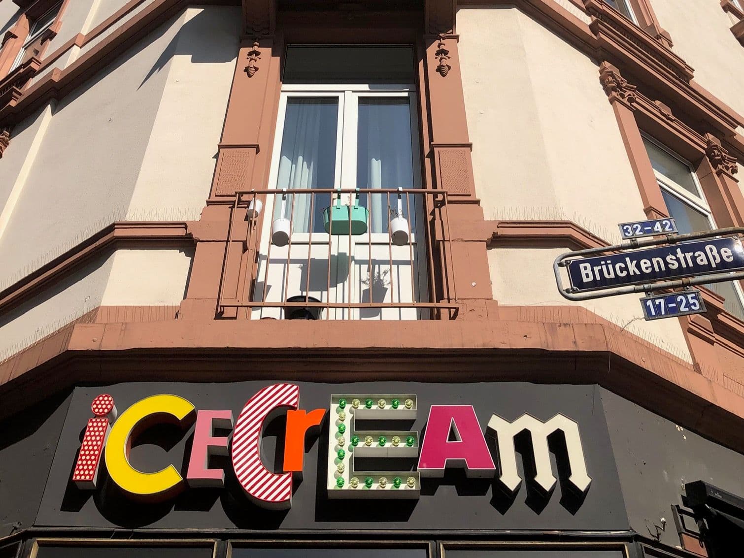 Ein Schriftzug in bunten Leuchtbuchstaben zeigt "Ice Cream" auf einer Hausfassade
