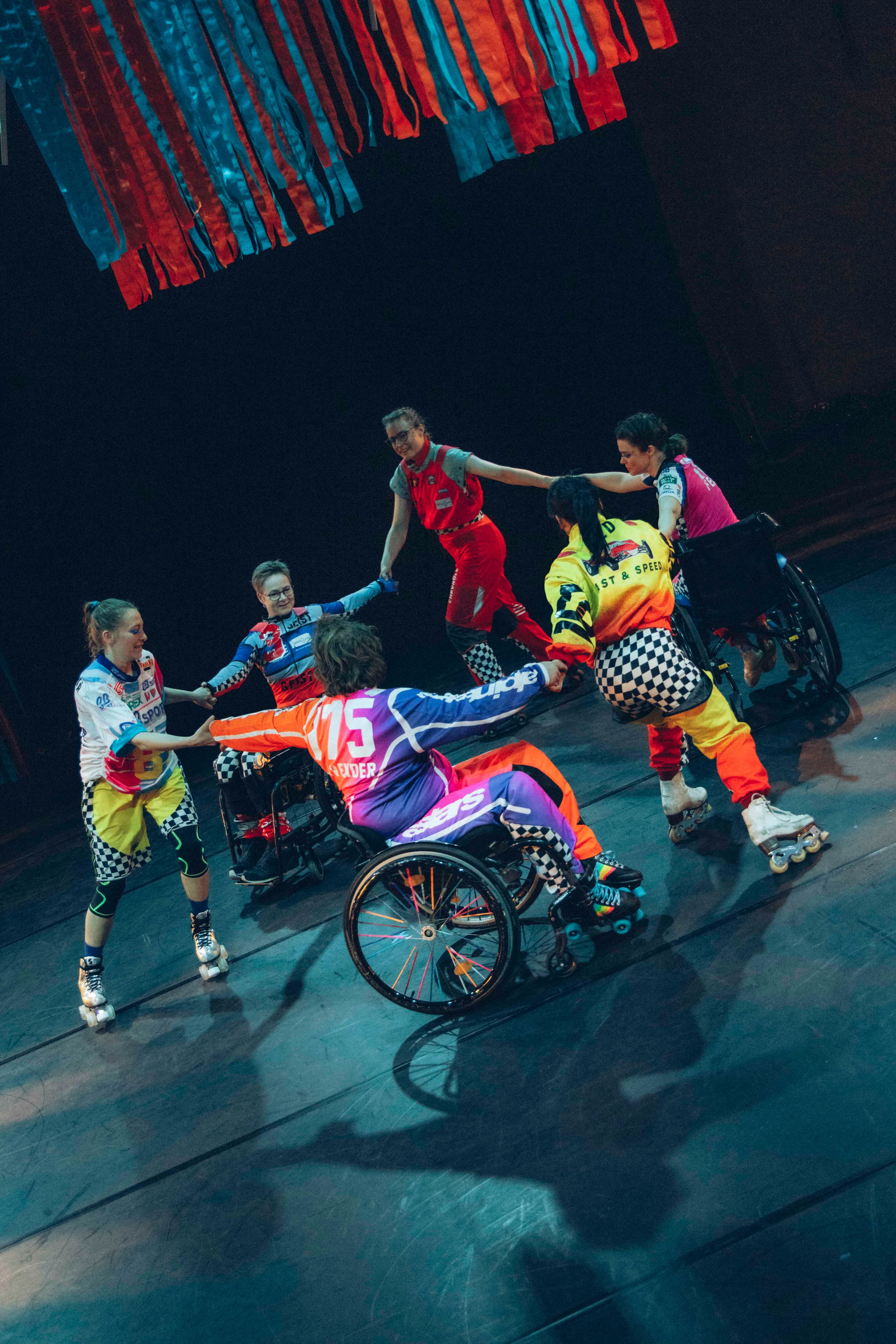 Bild einer Tanzperformance mit im Rollstuhl sitzenden Tänzer:innen